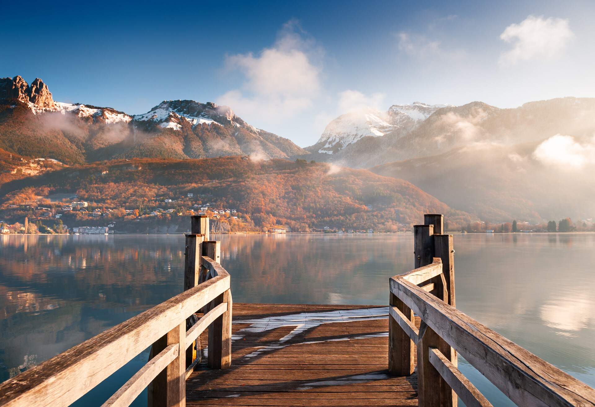 Wooden pier on Annecy lake in winter. Alps mountains, France.