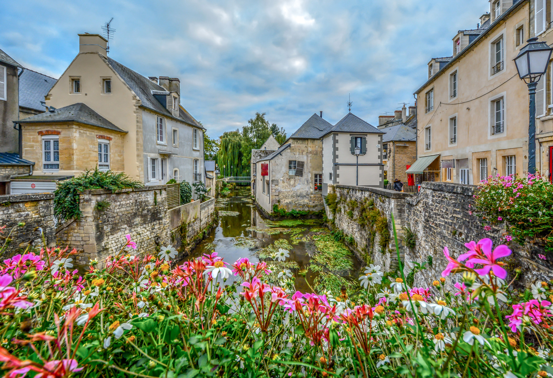 The picturesque French town of Bayeux France near the coast of Normandy with it's medieval houses overlooking the River Aure on an overcast day; Shutterstock ID 1050541298
