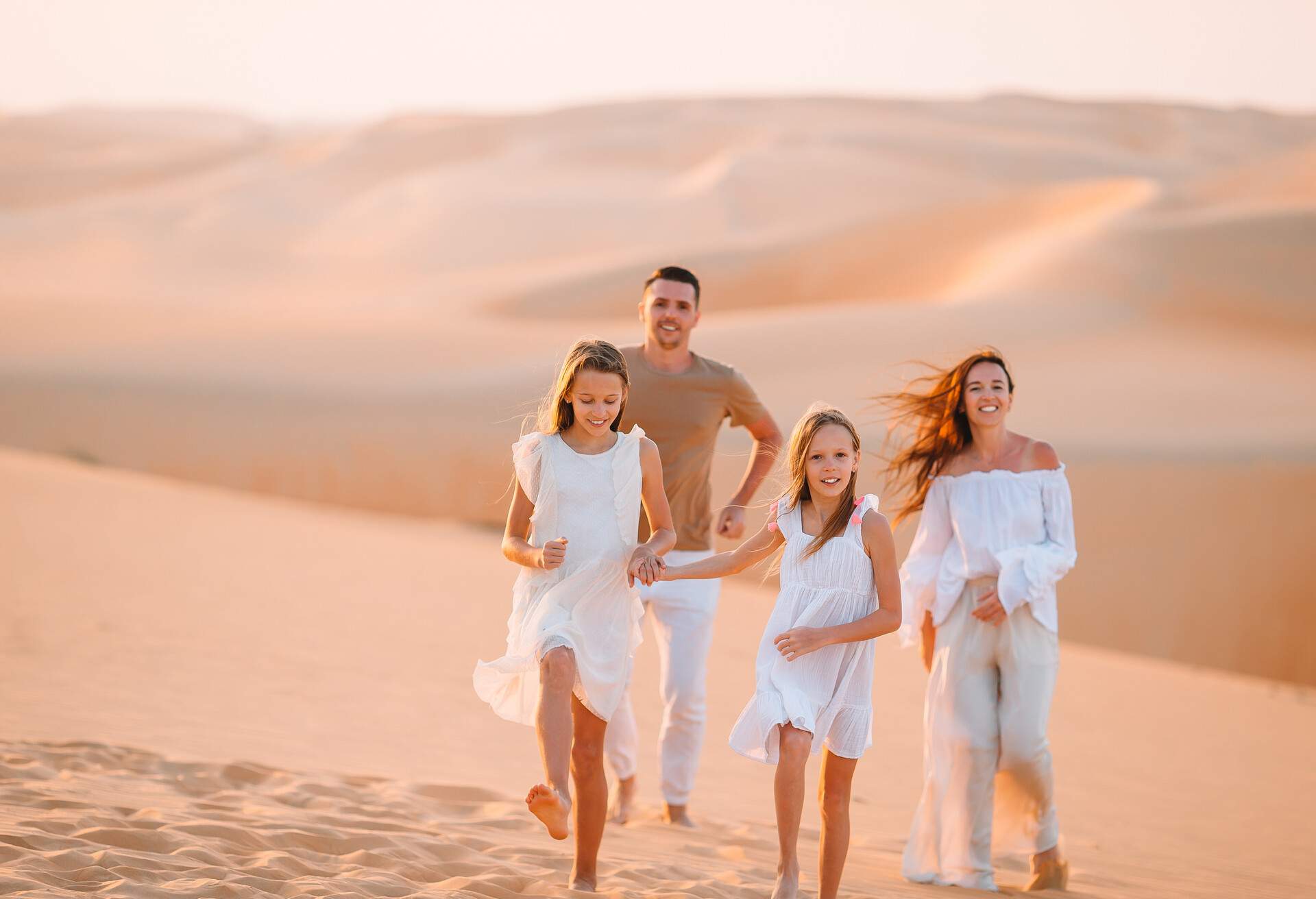 Parents and kids on vacation in dunes in big sand desert
