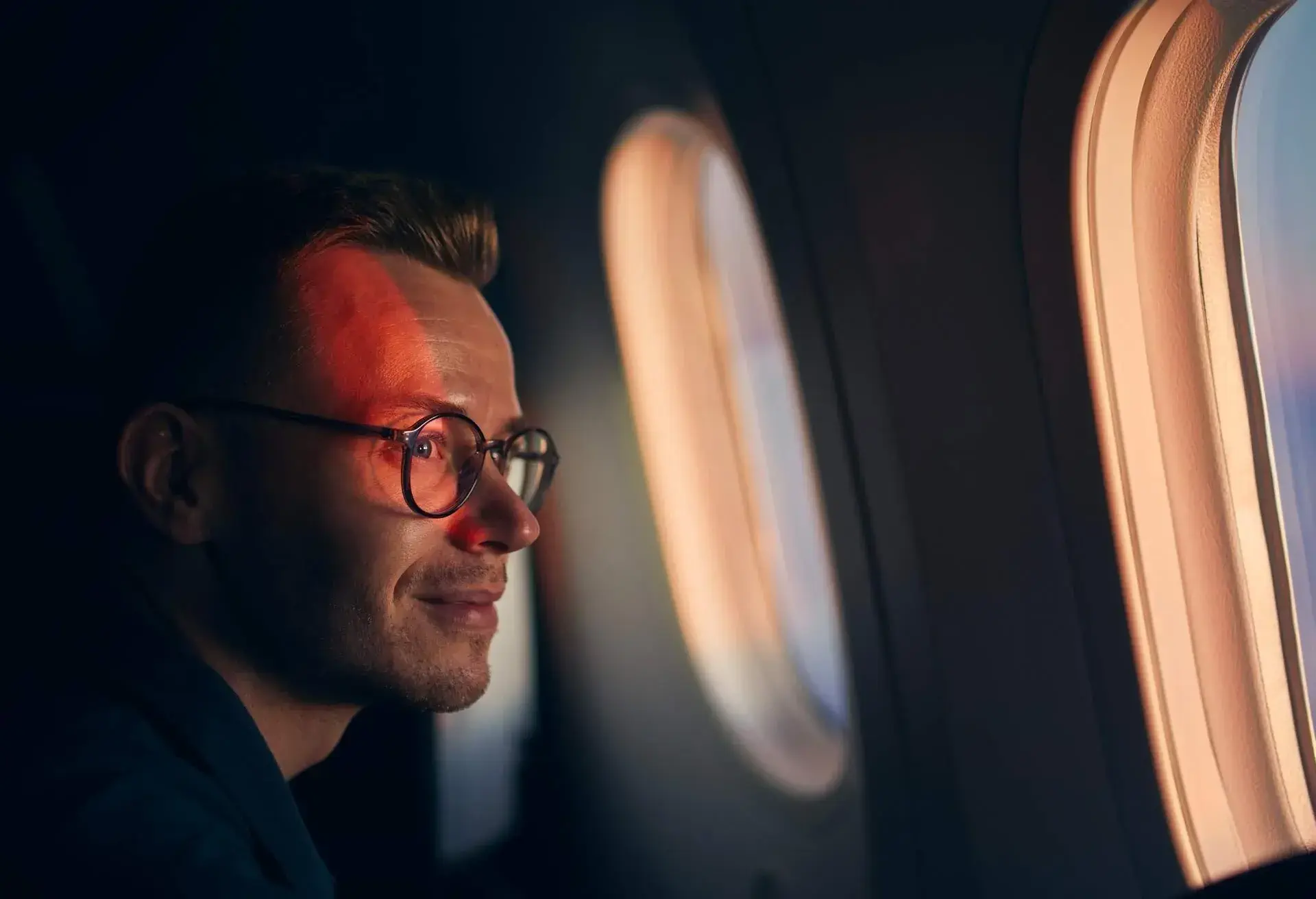 A man looking through a plane window
