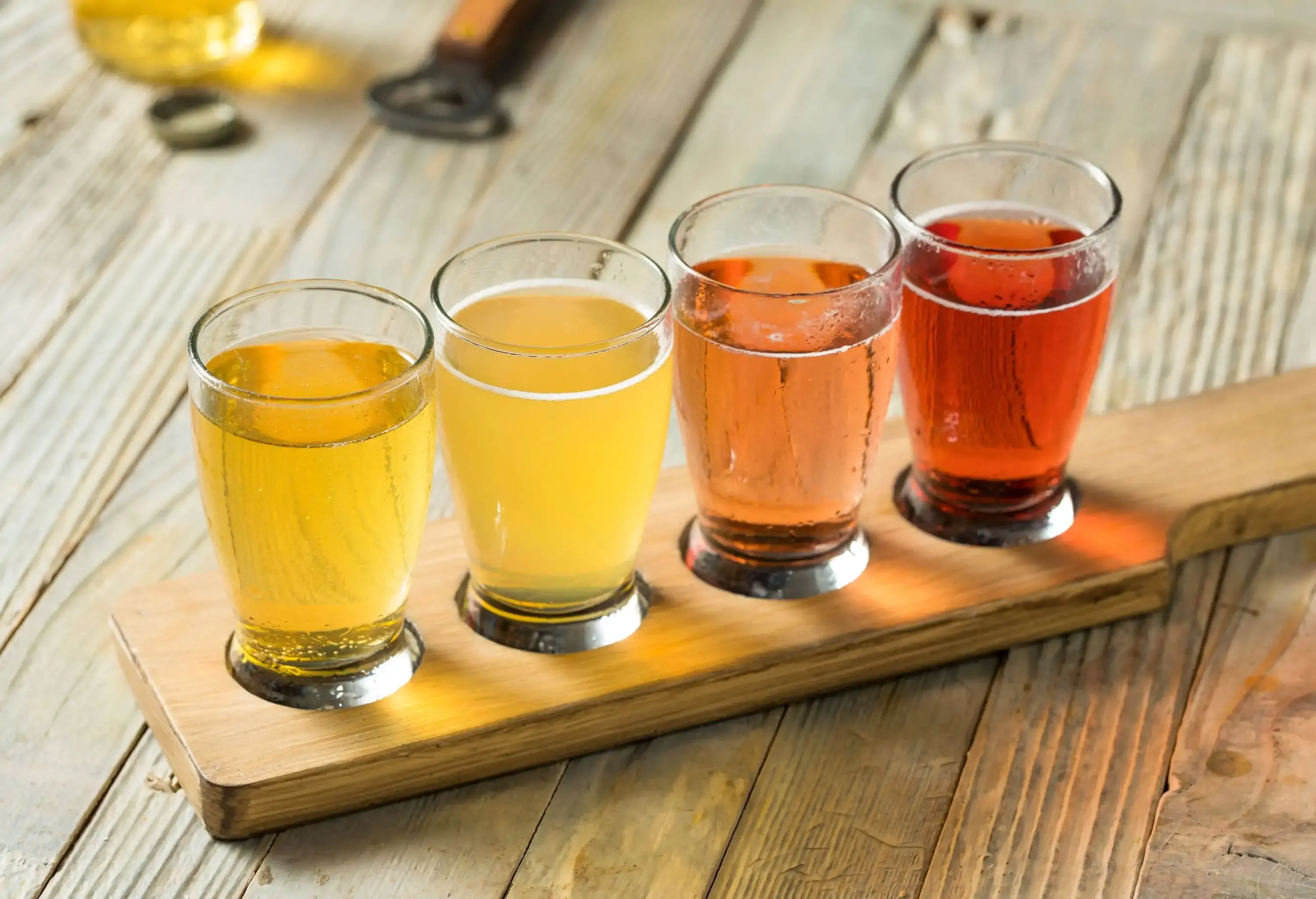 A flight of beer in small glasses.