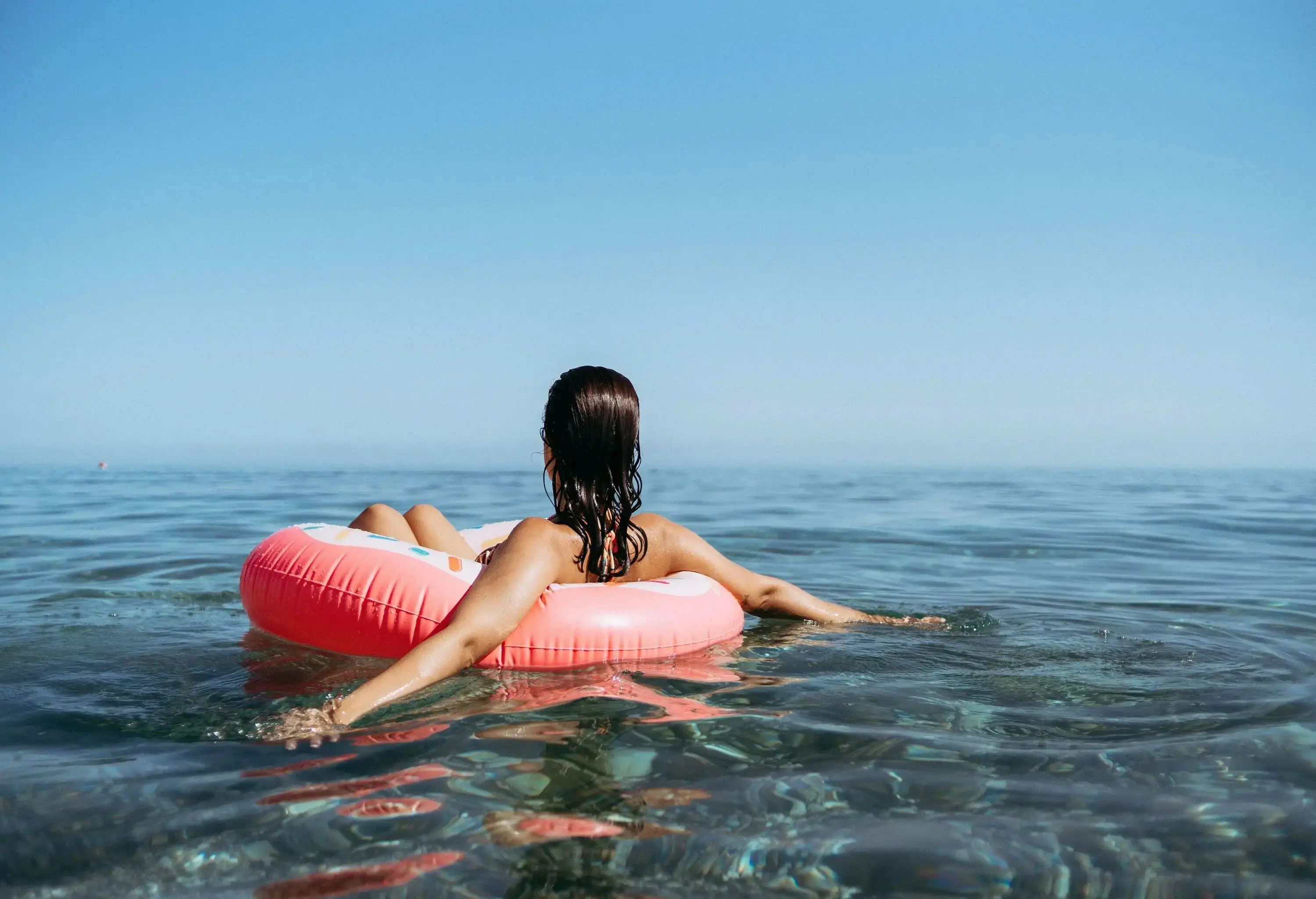A woman floating in the sea on a swimming ring.