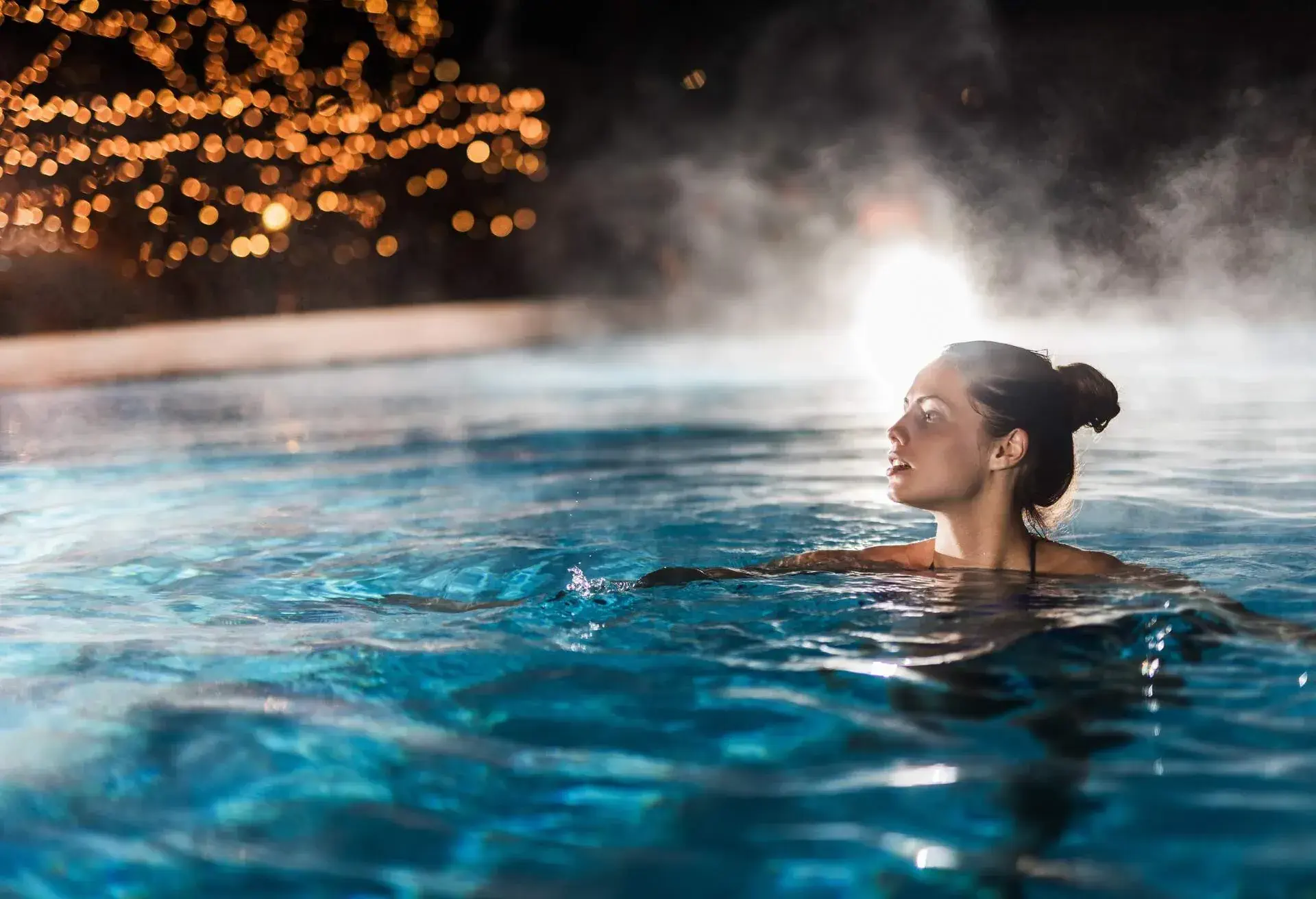Woman in hot water at night at a Budapest spa