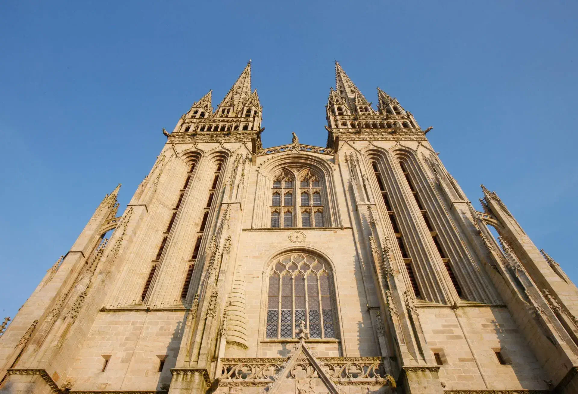 A church's facade with its twin tower and narrow arched windows.