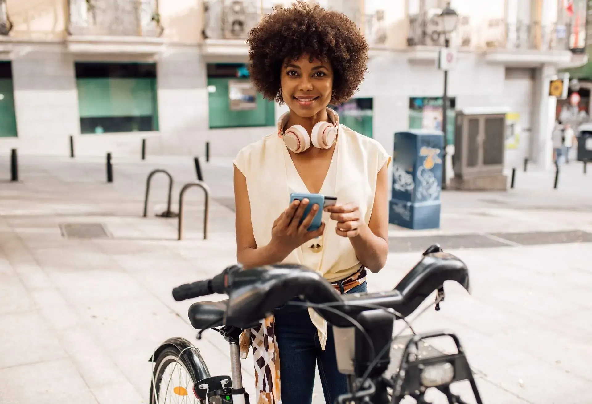 Young African American woman renting an e-bike to explore Madrid.
