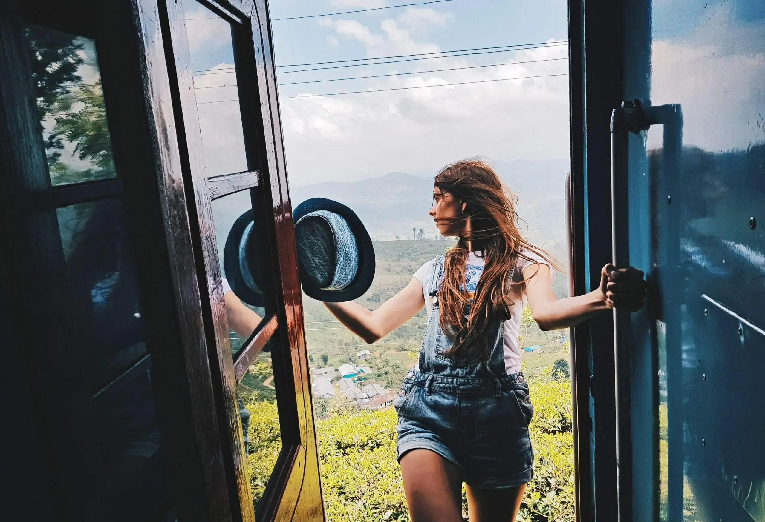 A young woman looking back at the scenery behind her as she prepares to board the train.