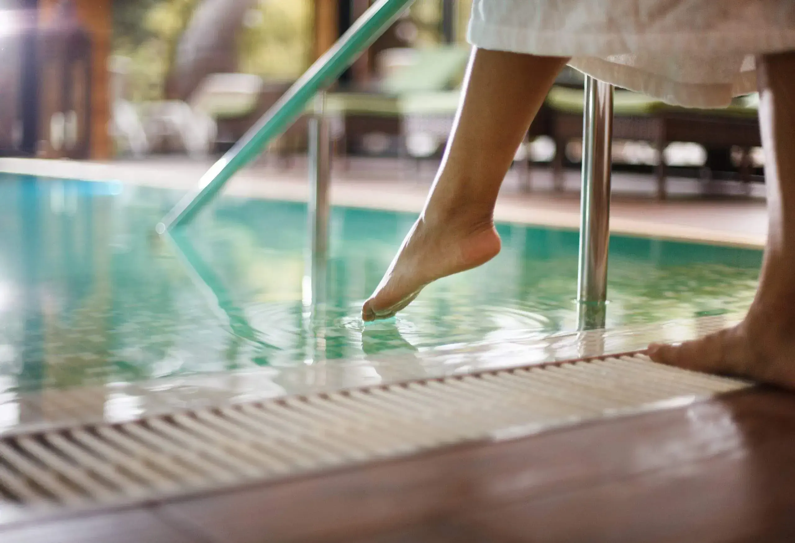 A person entering a swimming pool