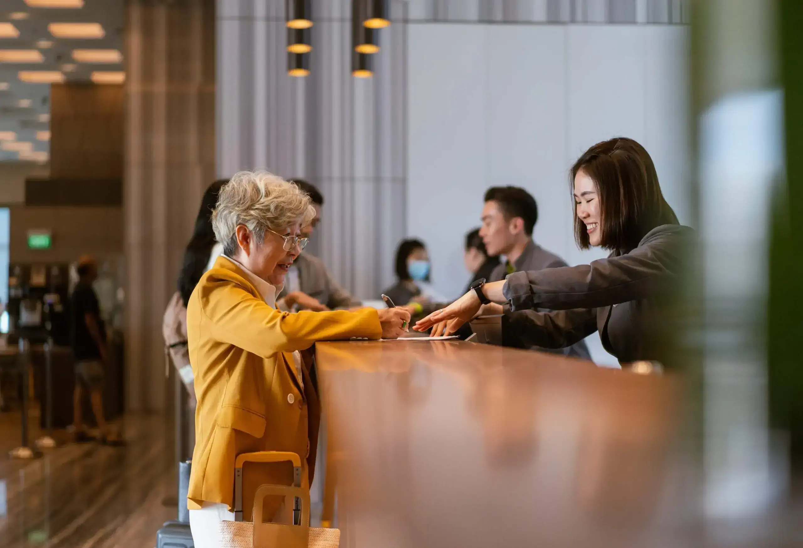 Business travel - Senior Asian businesswoman checking out.
