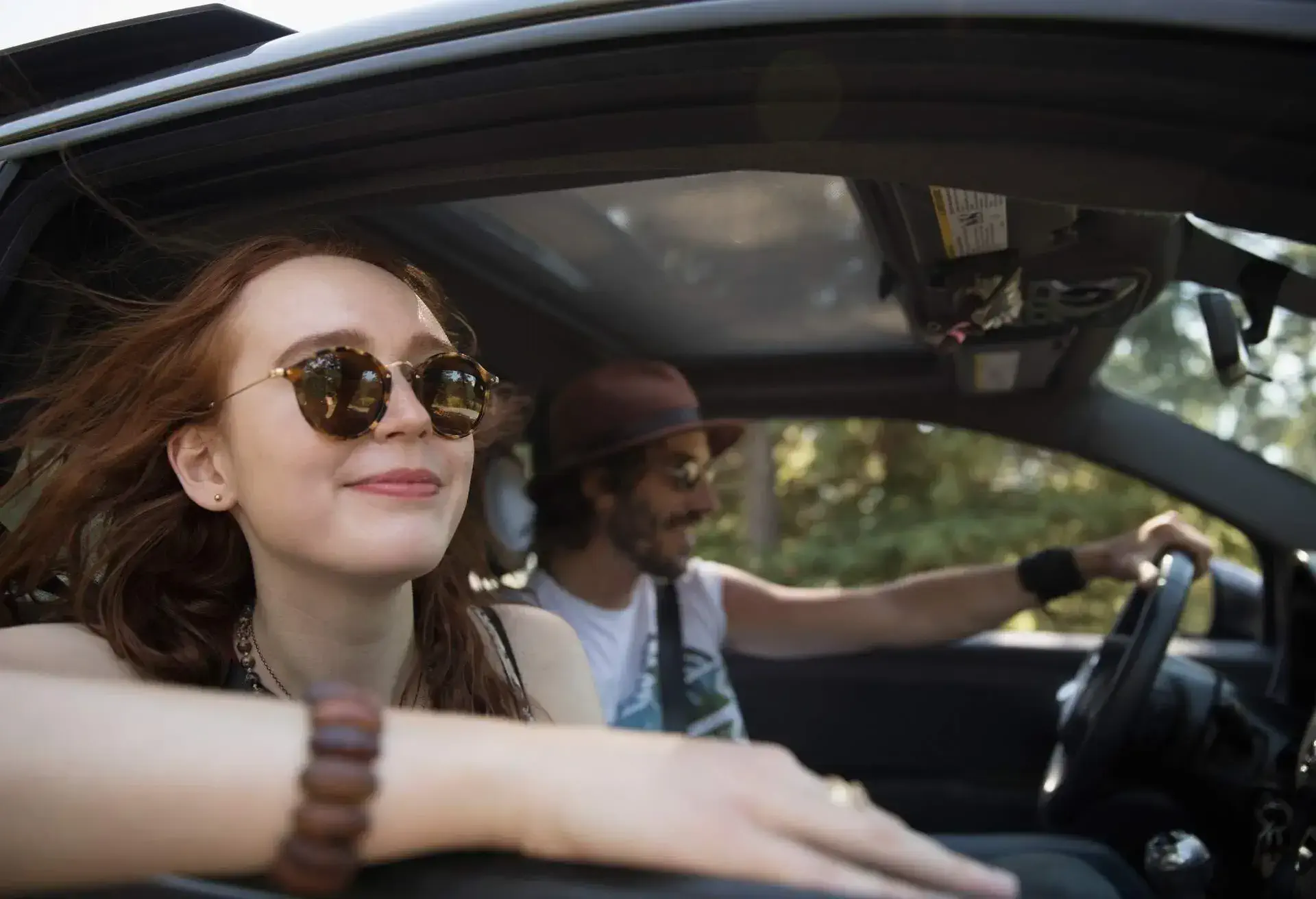 Couple in a car, driving with the window open