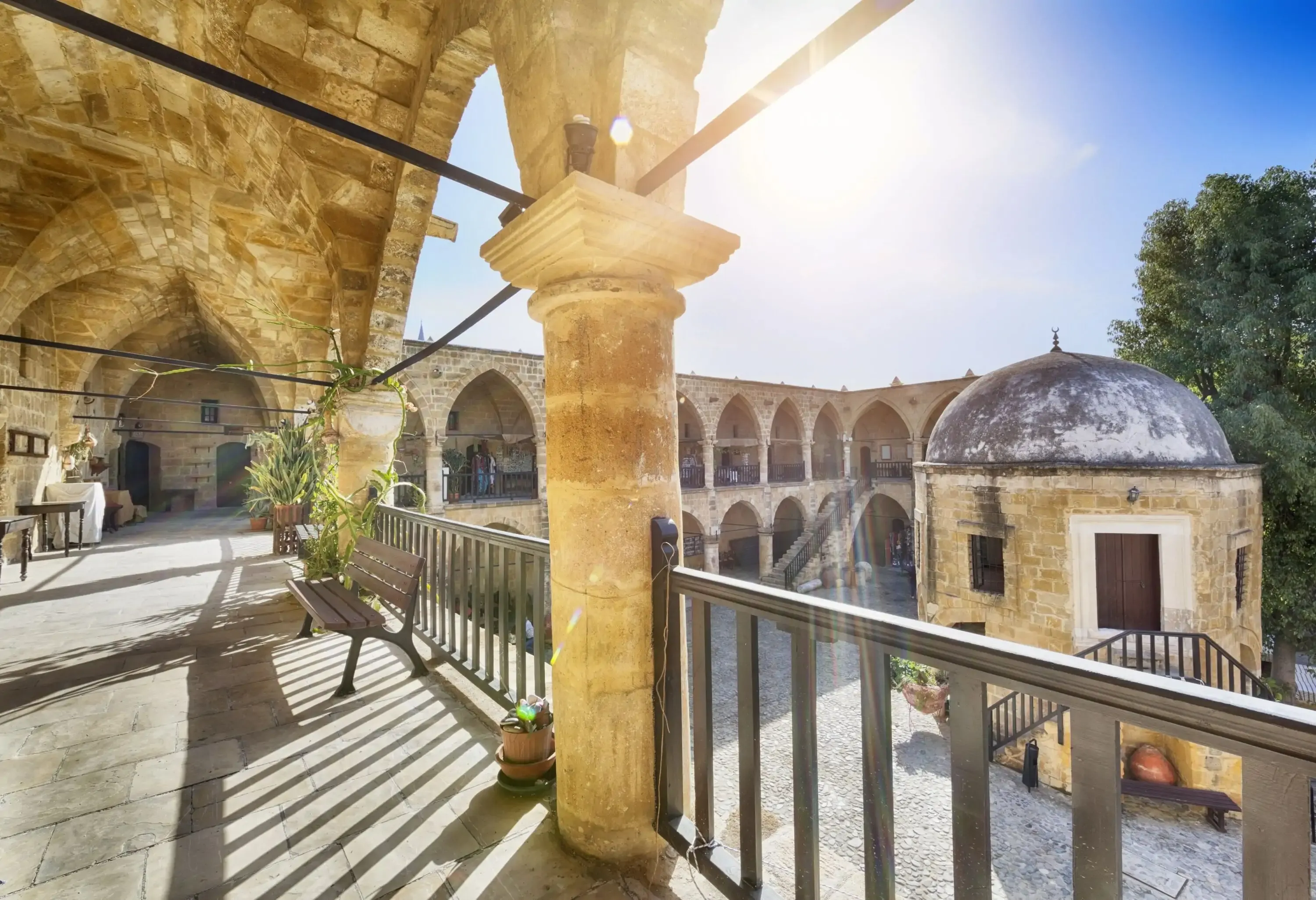 An arched stone arcade supported by round columns overlooks the courtyard.