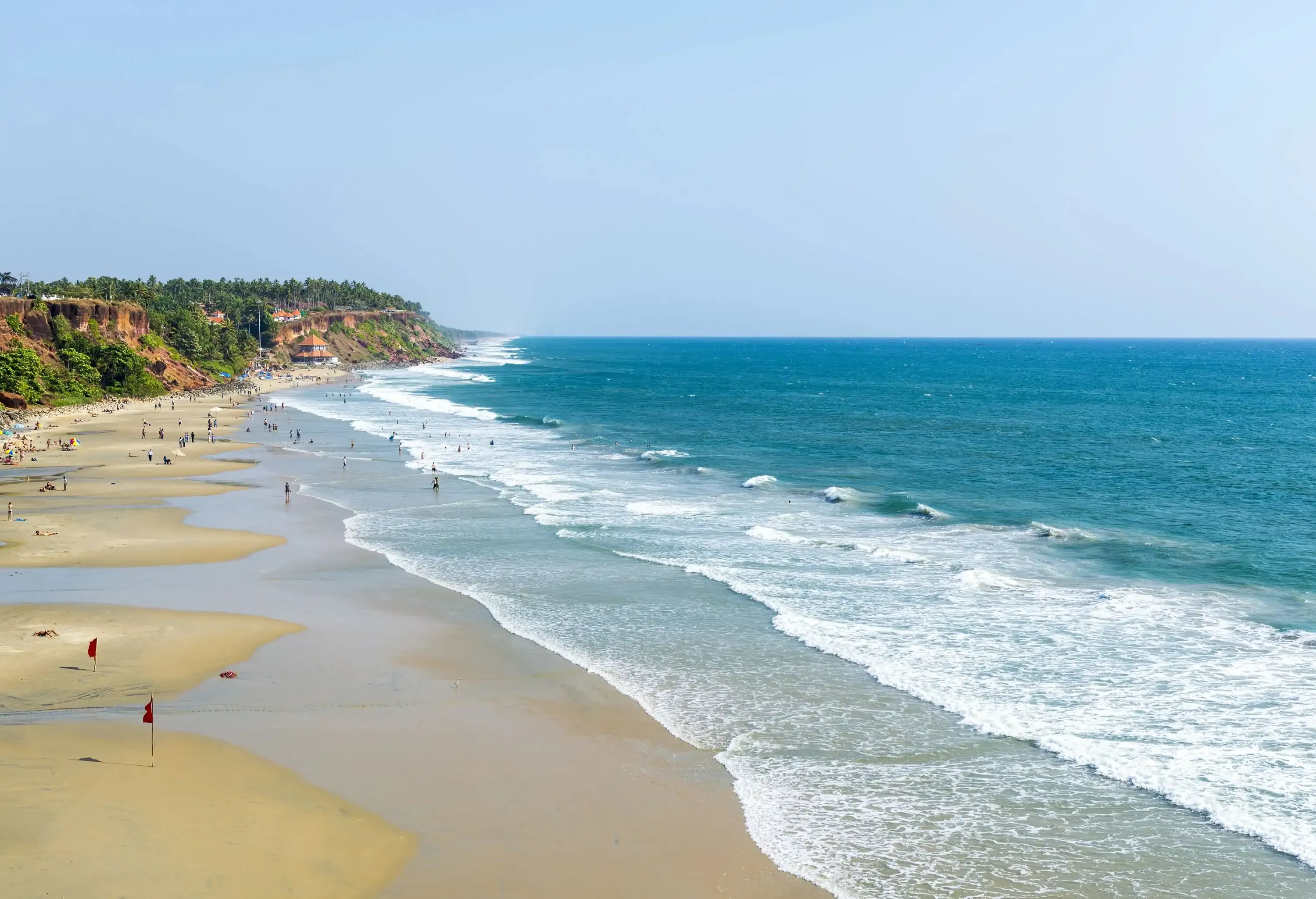 Waves slamming on the beach while people lounge on the sand.
