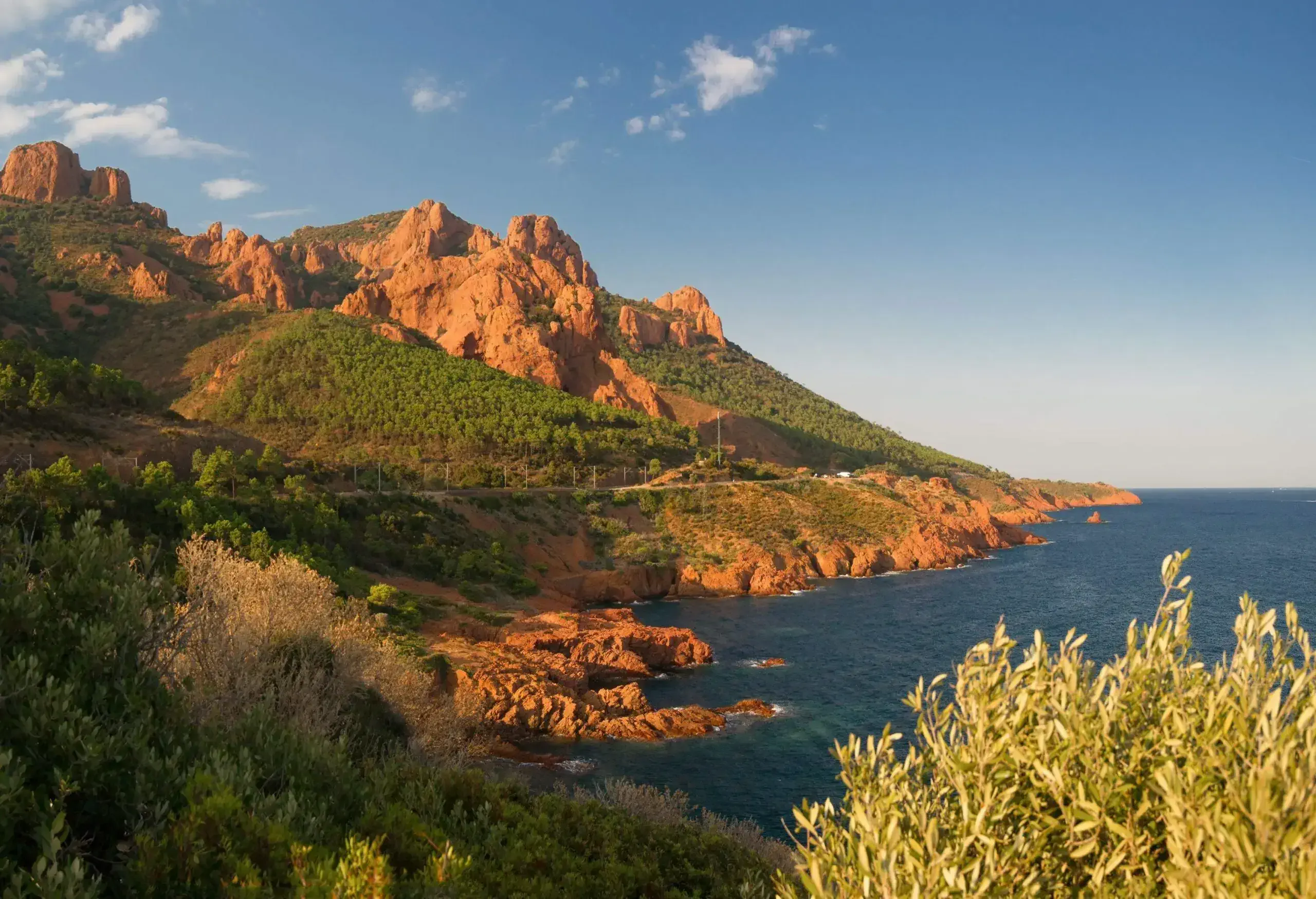 Red and orange volcanic cliffs and hills between Agay and Cannes in the Esterel massif.