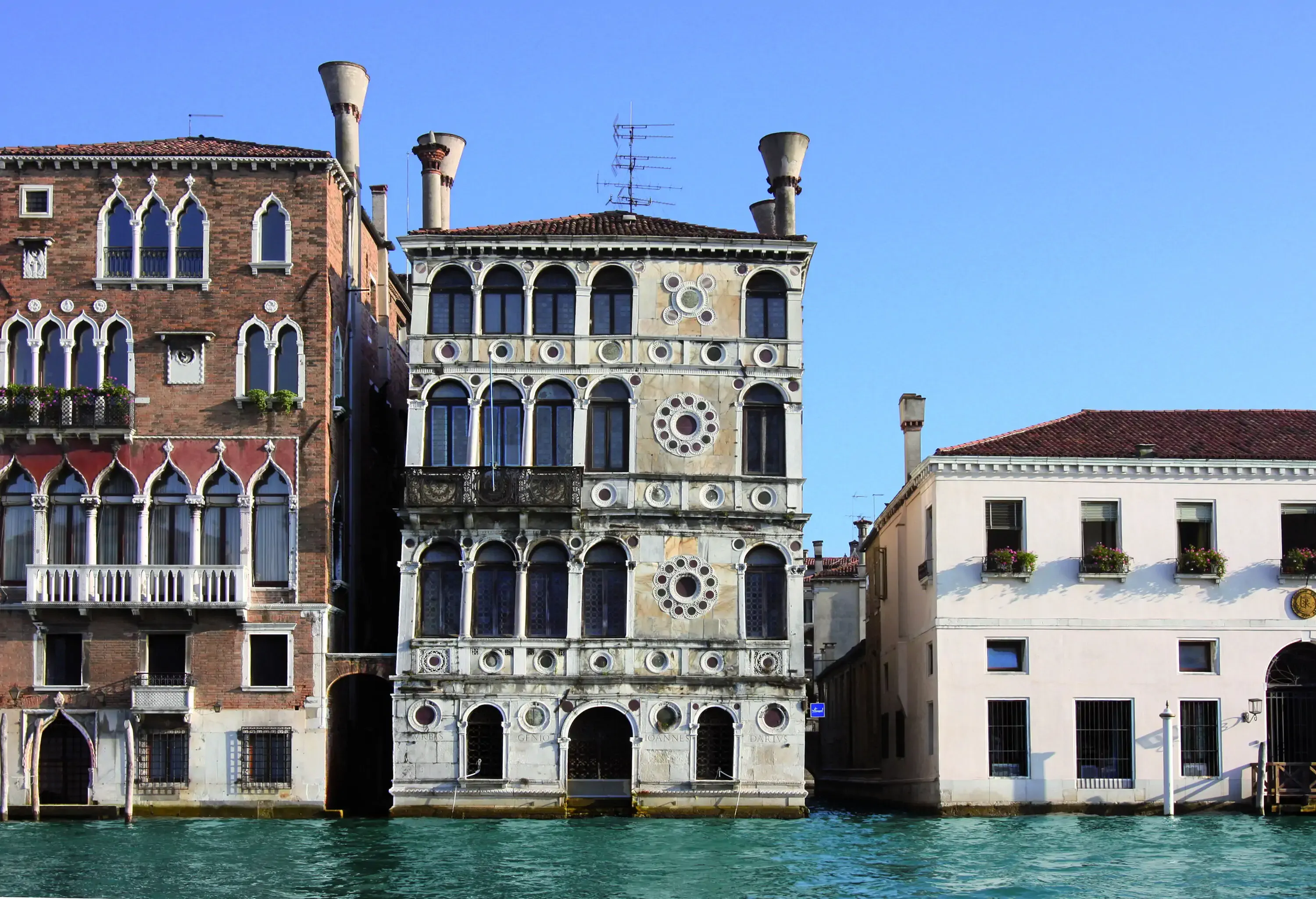 Palazzo Dario is a palace along a water canal with arched balconies and raised chimneys.
