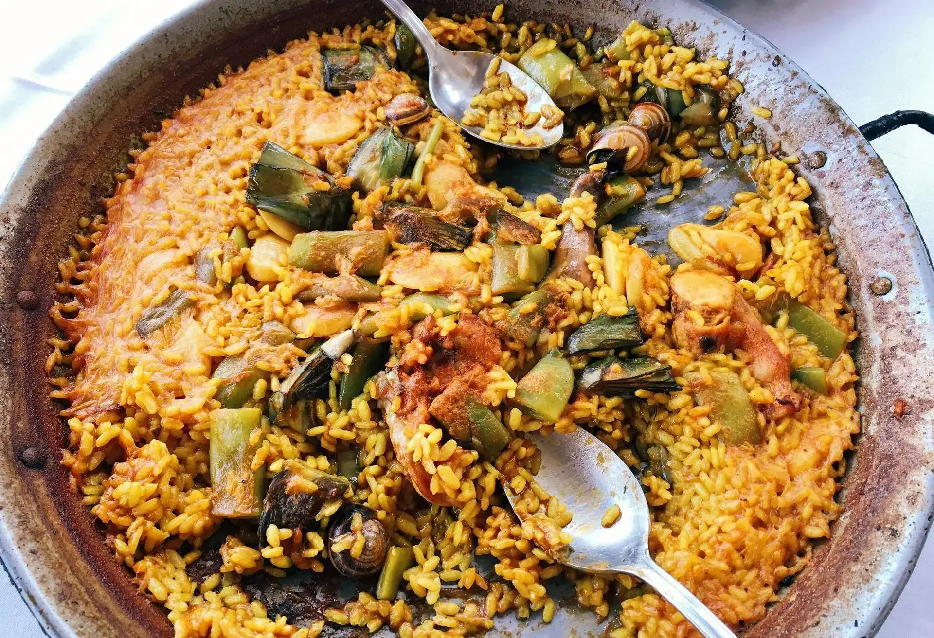 Paella Valenciana in a paella pan with spoons