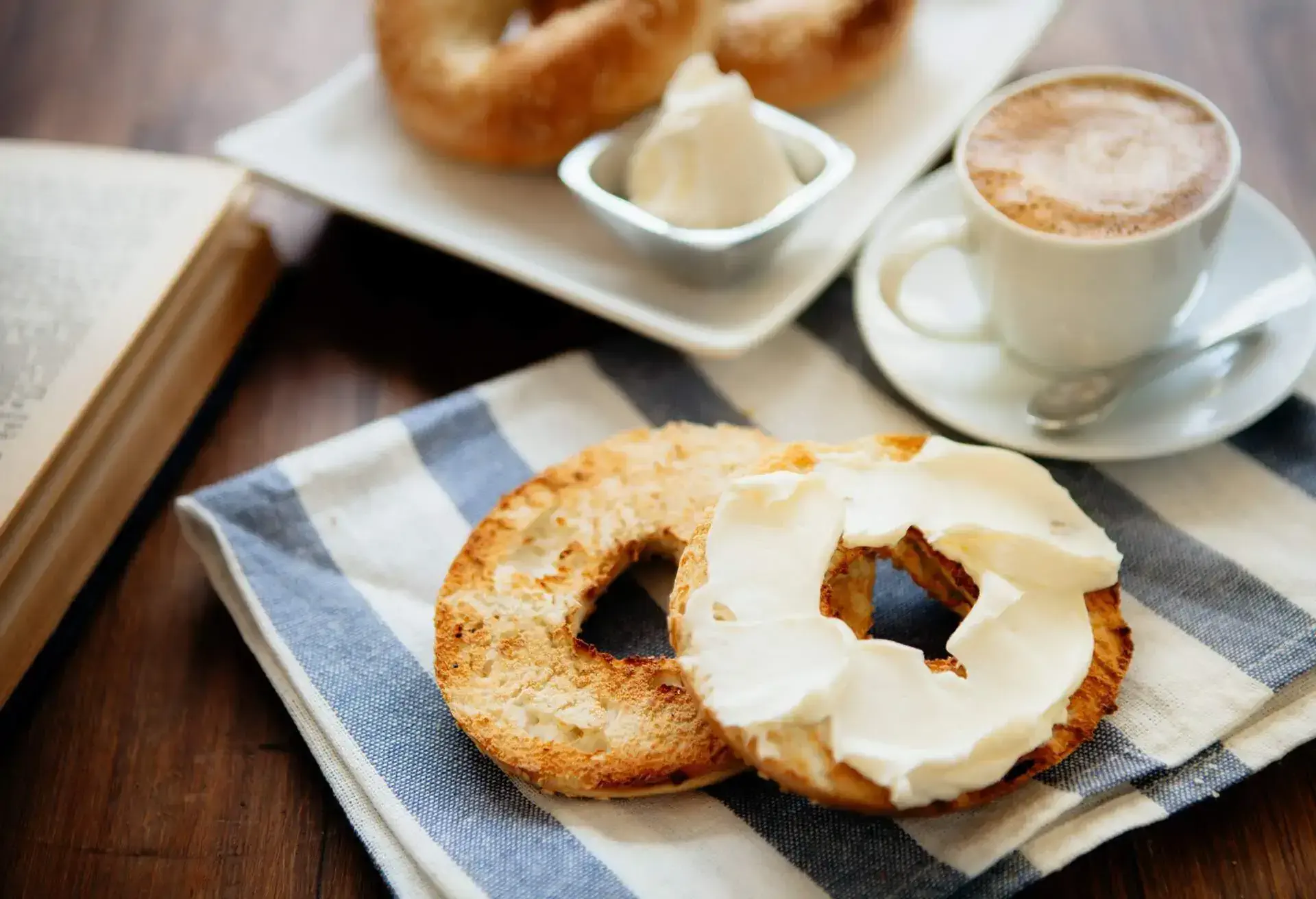 Bagel with creamcheese and cappuccino in a white cup