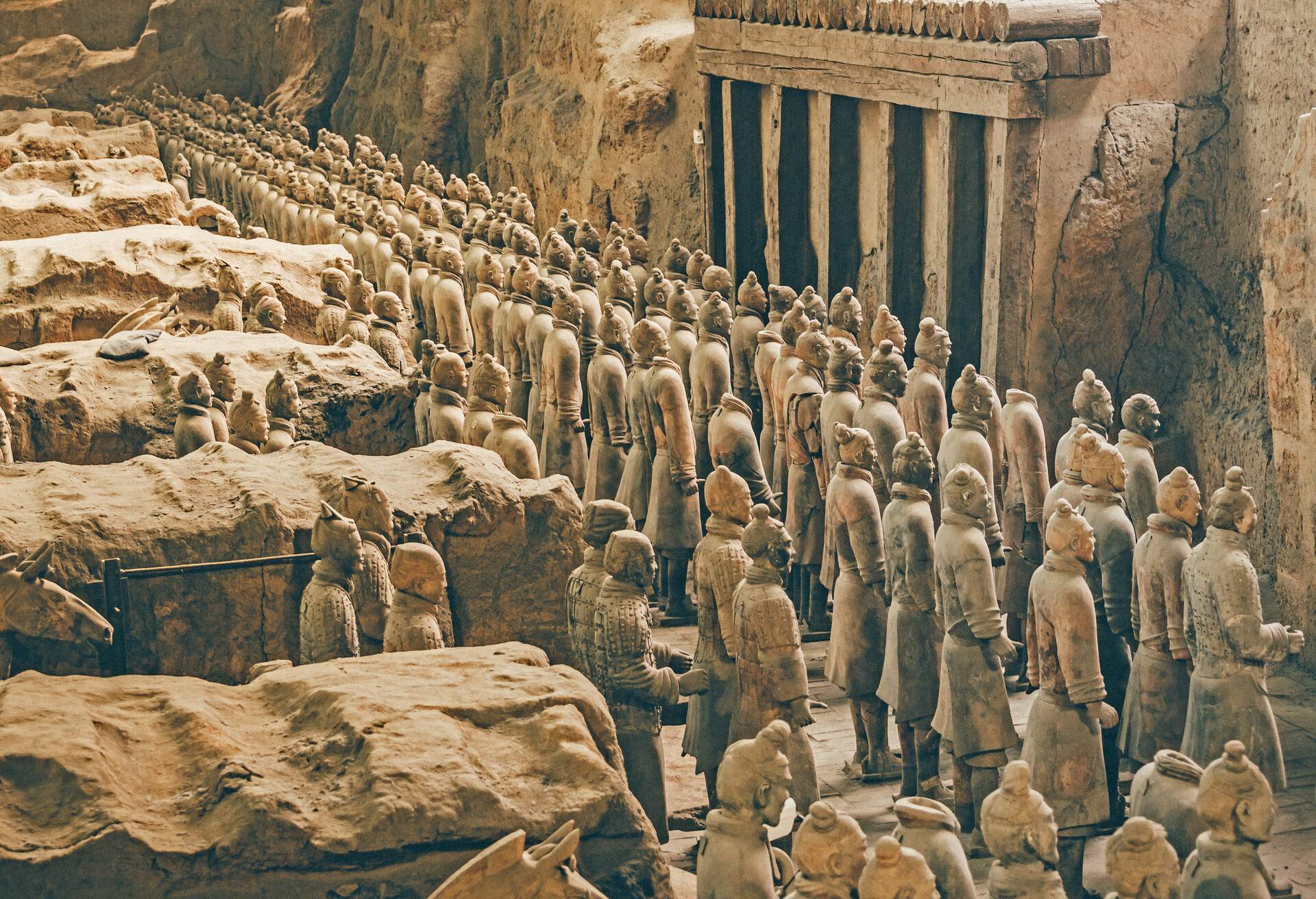 The Terracotta Army statues with chariots and horses behind them.