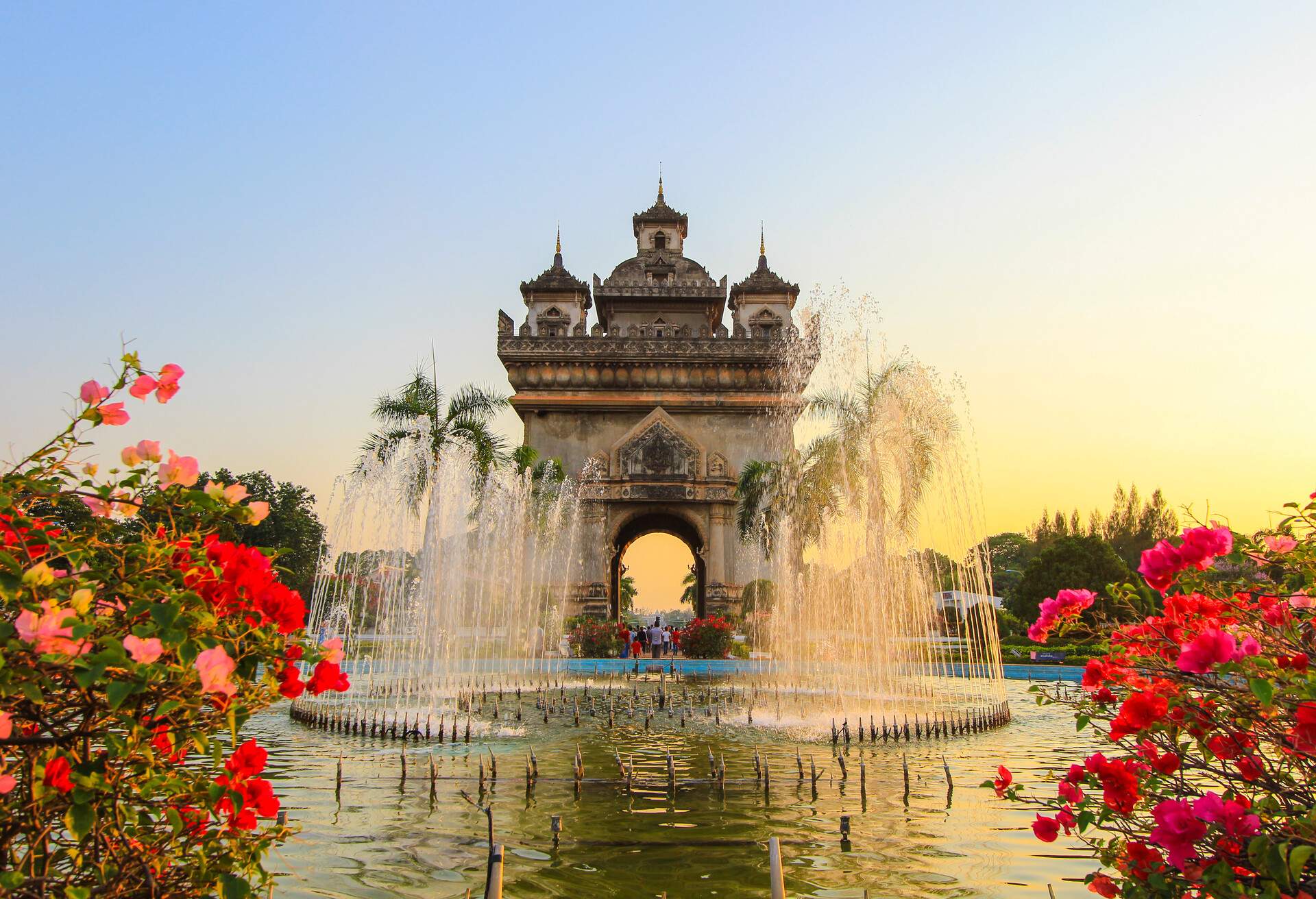 A stately war monument stands proudly on Lang Xang Avenue, with a captivating fountain in the foreground.