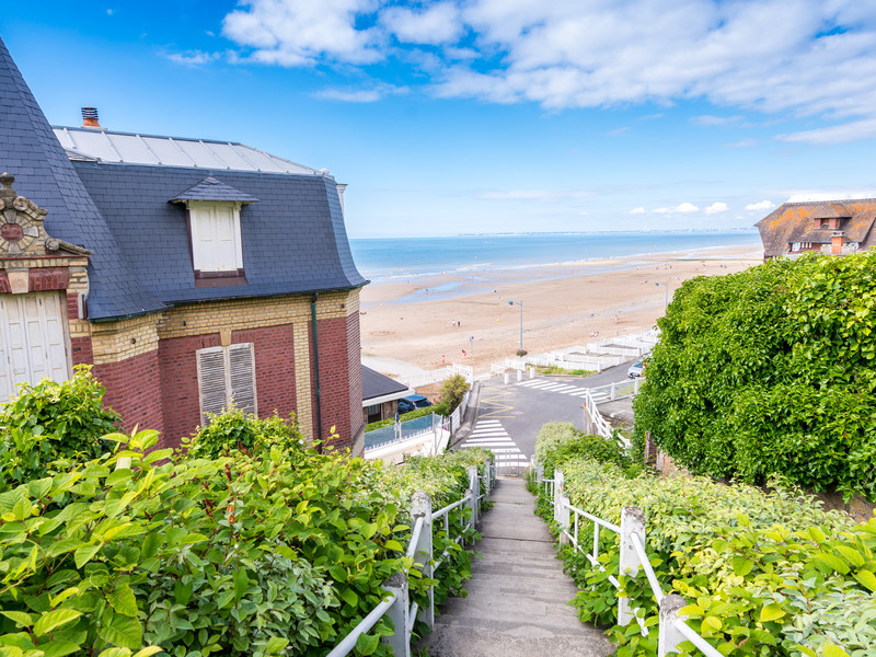 Un petit sentier fleuri relie les maisons à la mer à Deauville en Normandie, une destination idéal pour des vacances d'été en France