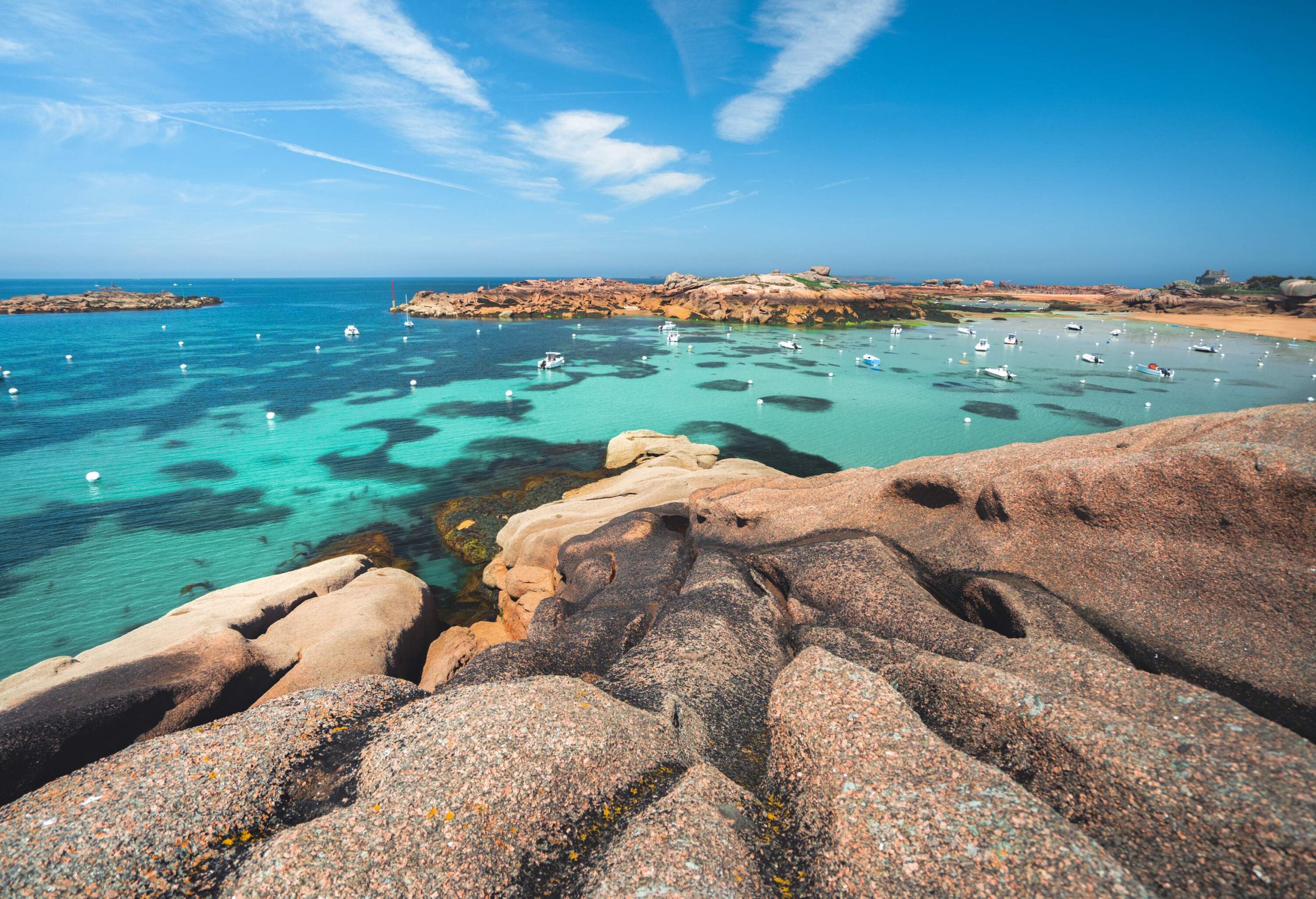 Close up of granite rocks with turqoise sea and beach in the background