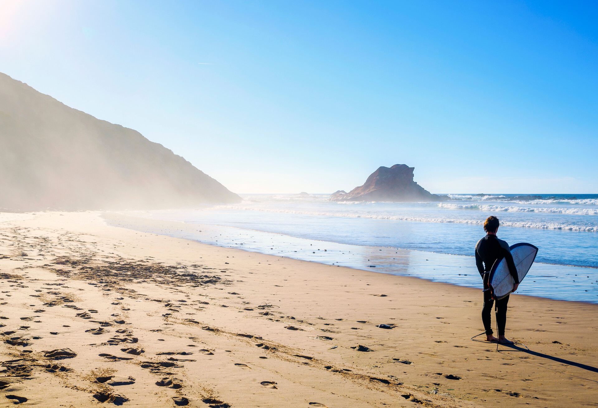 Surfer on wild beach in Algarve, western Portugal; Shutterstock ID 781019287