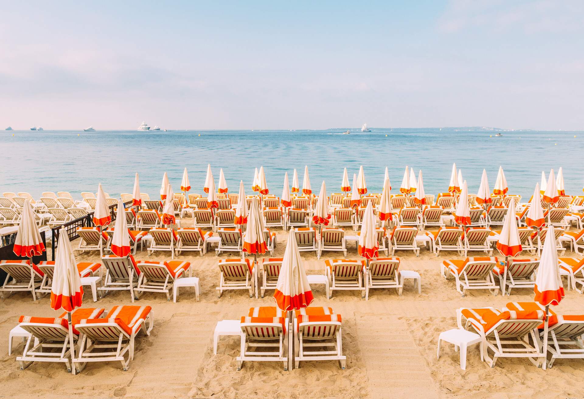 Sun loungers with umbrellas on the sand looking out at the stunning beach.