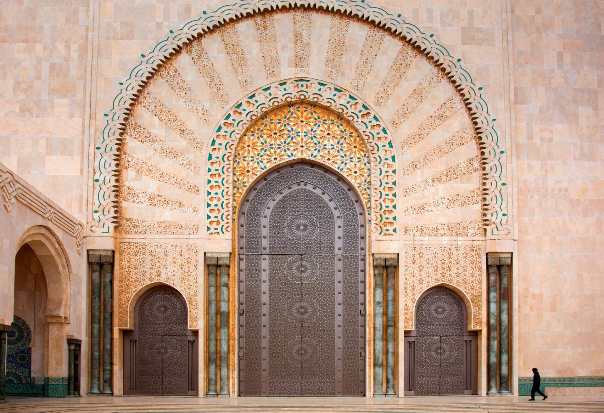 Morocco, Casablanca, Hassan II mosque, side entrance of main mosque. small man wlaking for scale . huge entrance doorway.