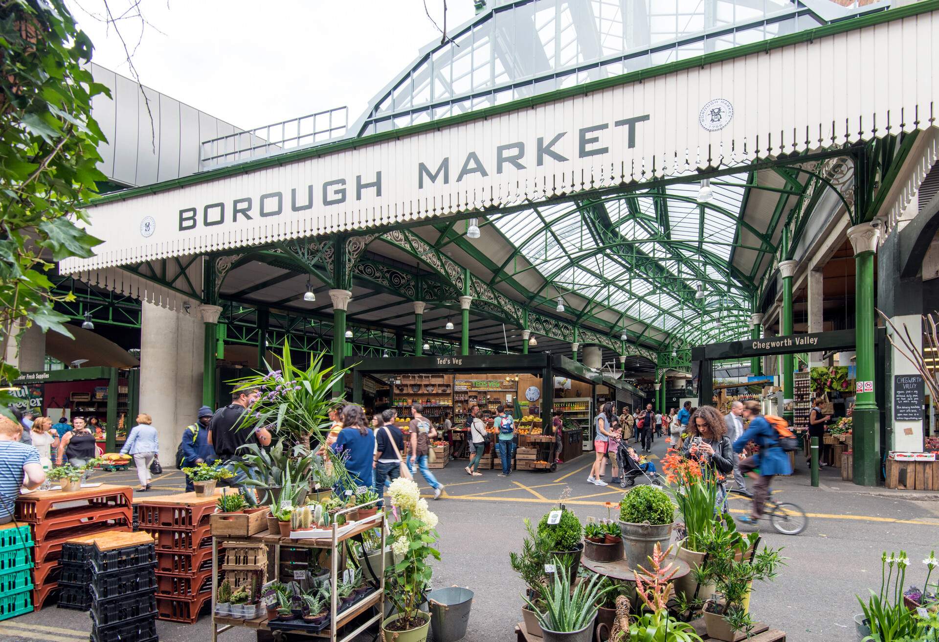 Lots of shoppers and vendors at Borough's open-air market with a glass ceiling.