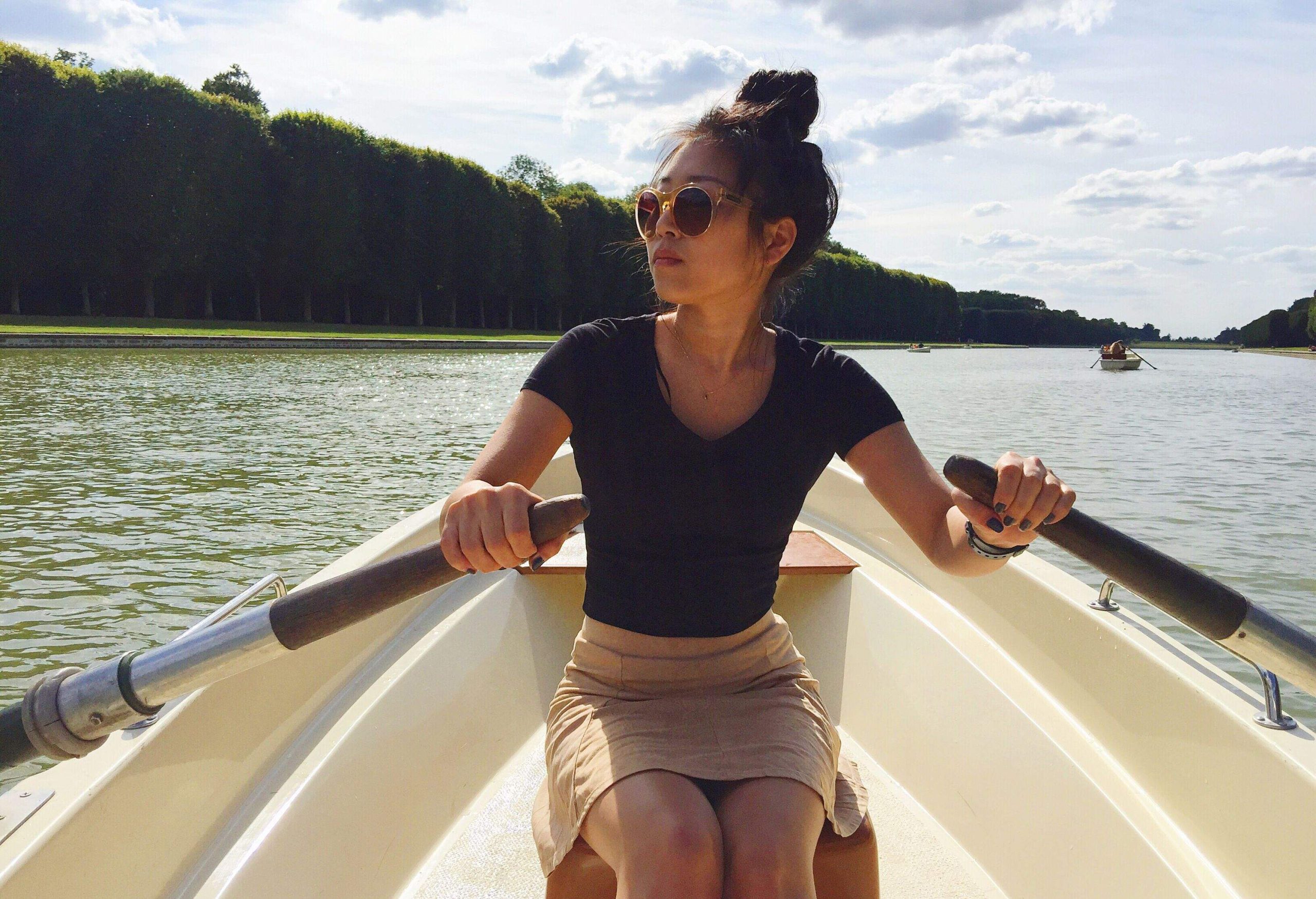 A woman looking away as she paddles the boat across the water.