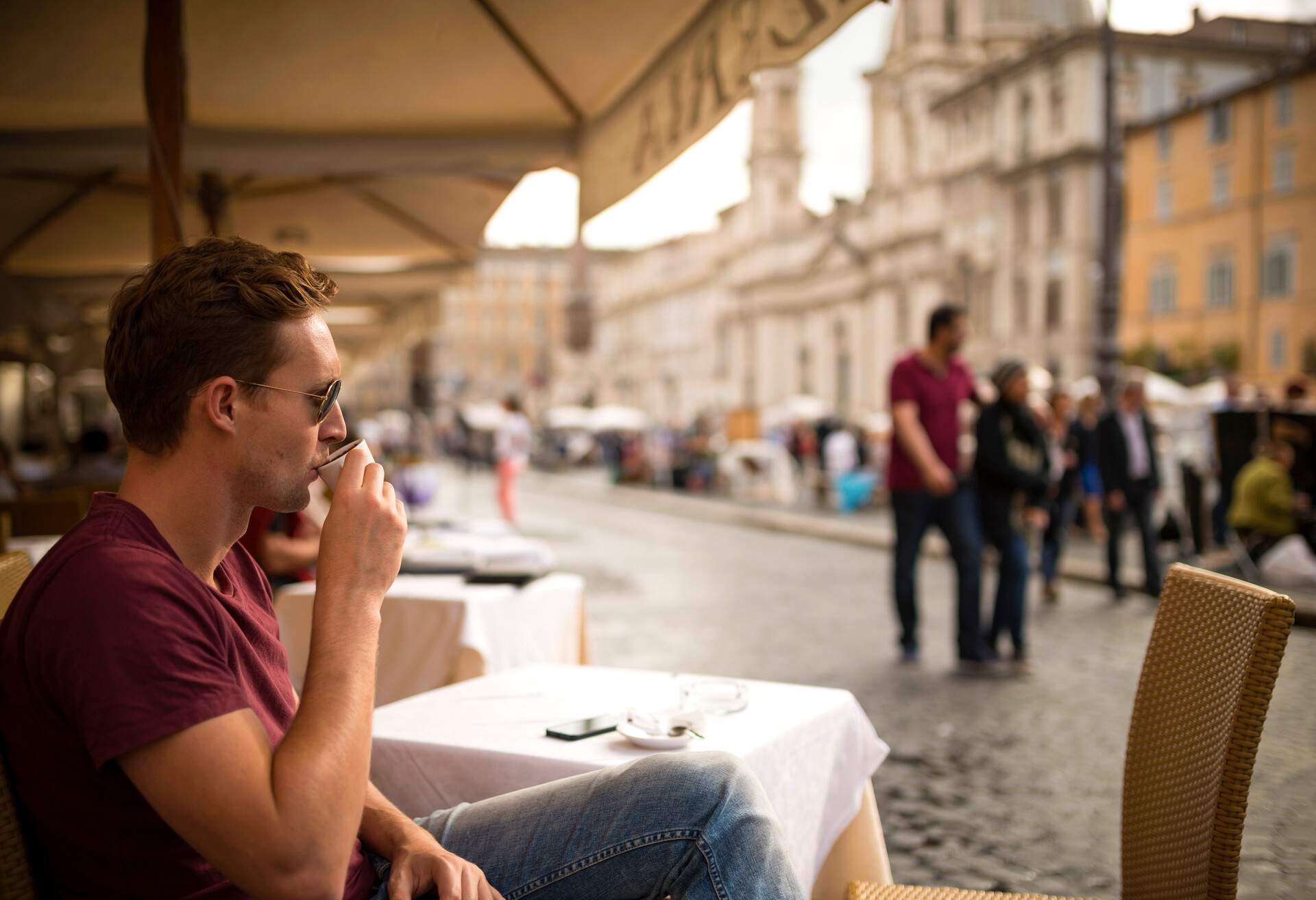 Young man enjoying Espresso at restaurant, Piazza Navona, Rome, Italy