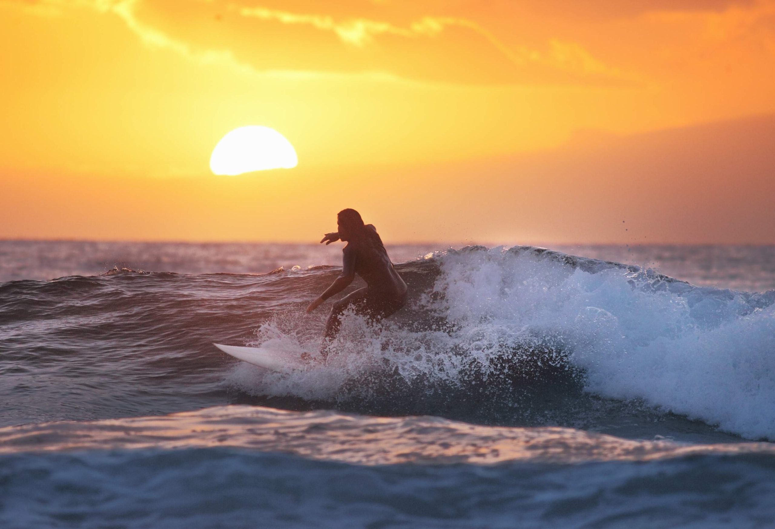 A surfer riding the waves in the midst of the sea.