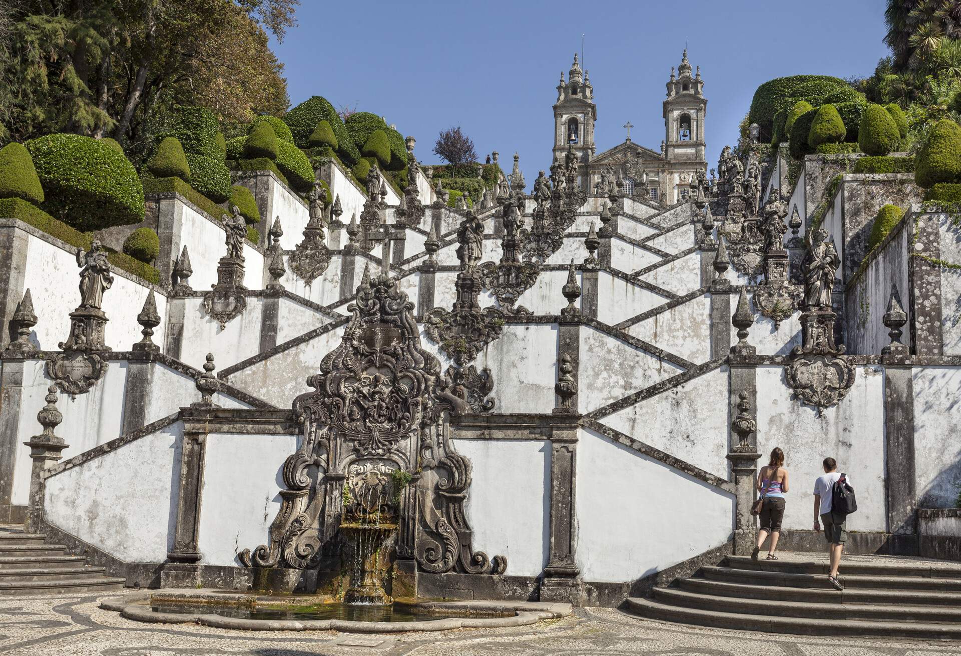 Tourists are approaching stairs with saint's statues leading to the church Bom Jesus do Monte near Braga, Portugal; Shutterstock ID 330222647; Purpose: momondo European city breaks 2019; Brand (KAYAK, Momondo, Any): momondo