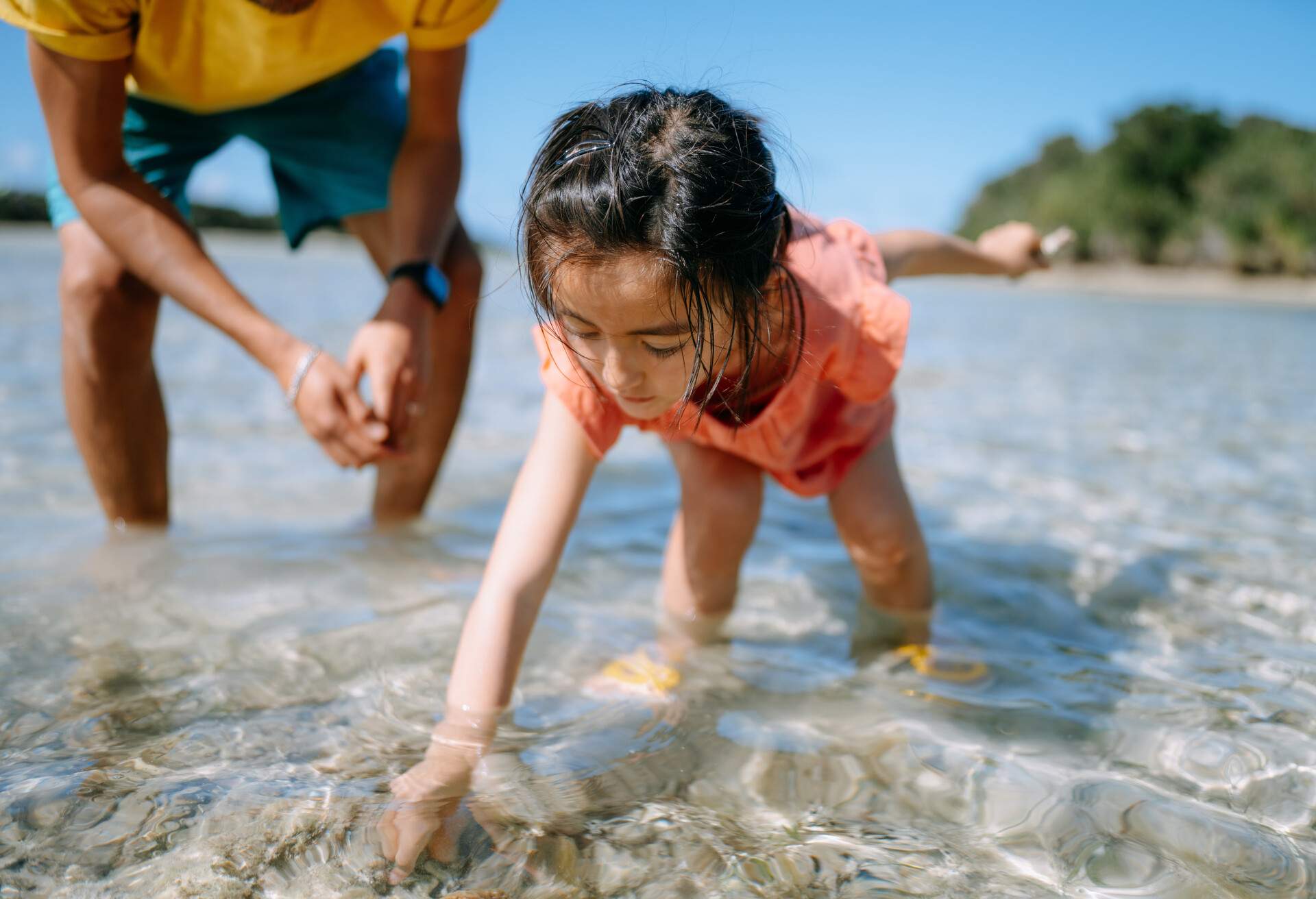 Cute young daughter playing in shallow tropical water, Iriomote-Ishigaki National Park of the Yaeyama Islands, Okinawa, Japan