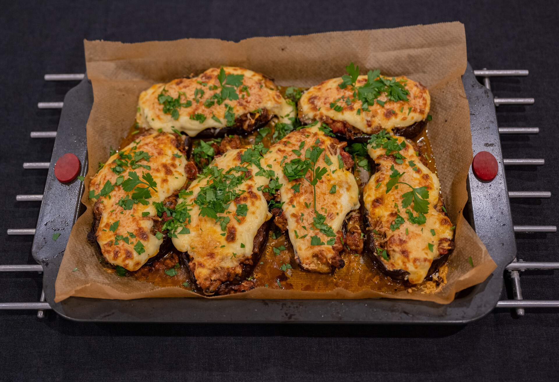 Bechamel and cheese covered mince in Aubergine 'slippers' - baked and sprinkled with parsley