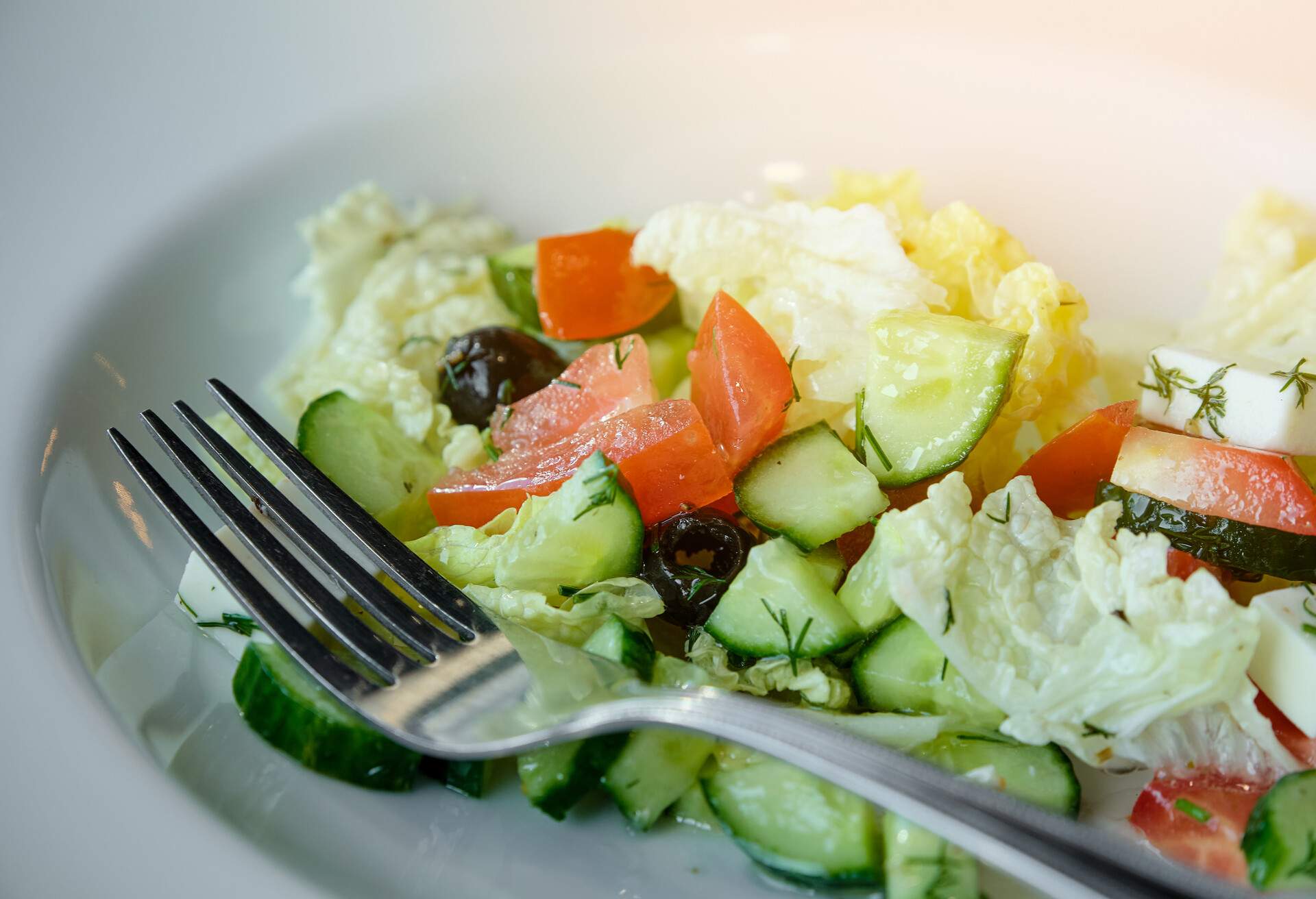 Greek salad with feta cheese, olives, juicy tomatoes, red pepper, cucumber and lettuce leaves. The concept of healthy eating. Vegetarian and vegan food. Natural products from an organic farm. Vegetable low-carb diet.