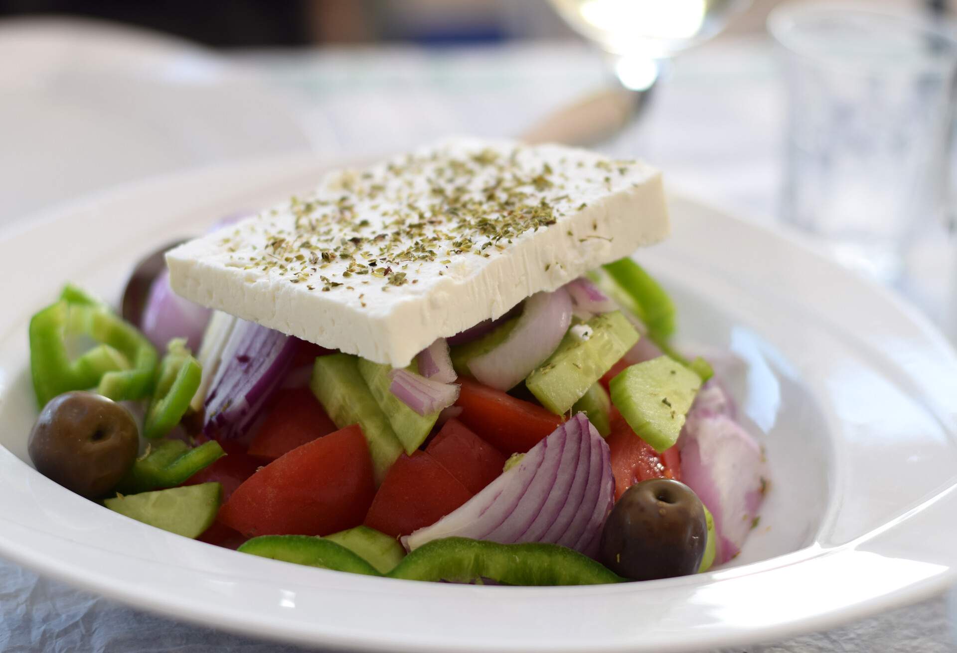 Close-up of a plate of Greek salad topped with feta cheese with oregano