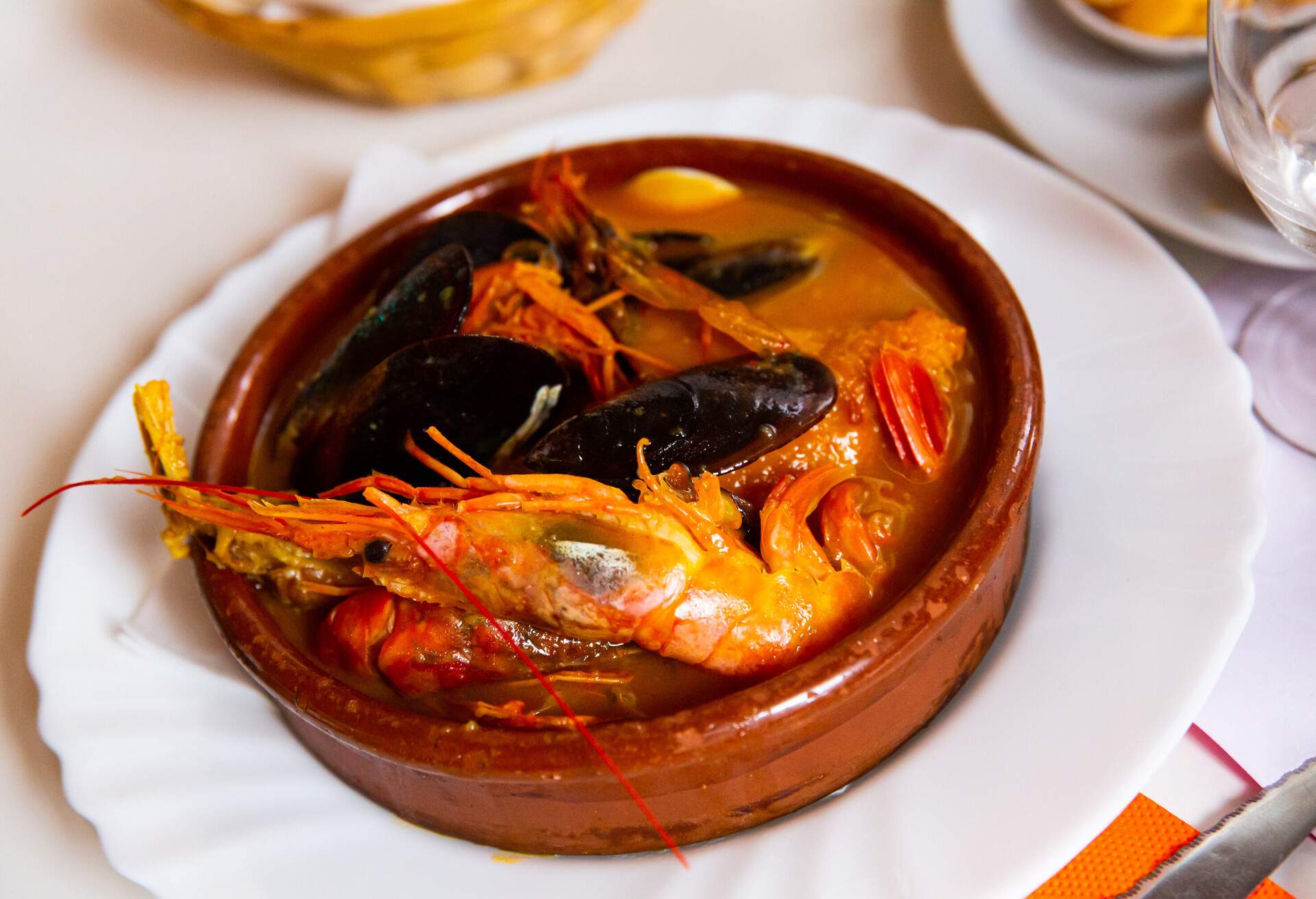 Typical homemade Catalan salsa suquet - thick seafood stew with shrimps and mussels traditionally served in clay bowl