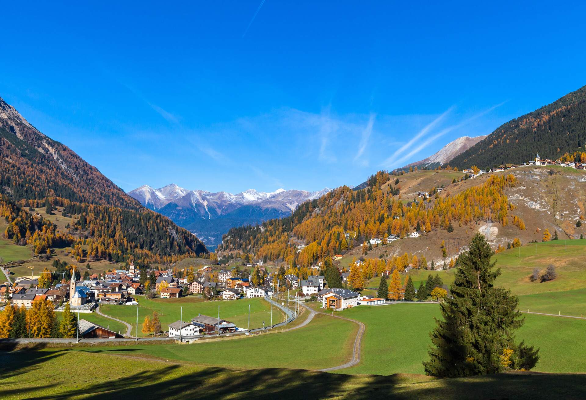 Beautiful view of the village of Filisur and the alps from the sightseeing train Bernina Express in golden autumn with corlorful trees, Canton of Grisons, Switzerland; Shutterstock ID 402382954; Purpose: destiny; Brand (KAYAK, Momondo, Any): any