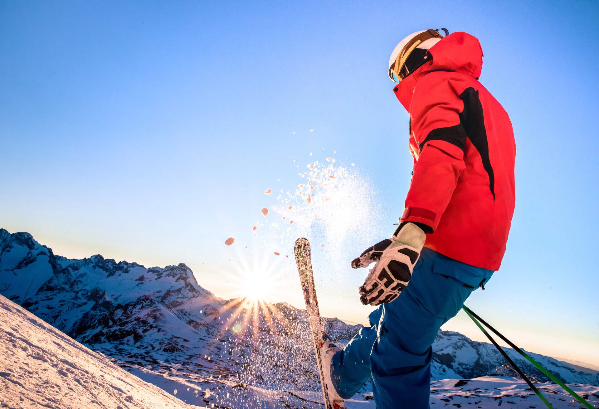 Professional skier at sunset on relax moment in french alps ski resort - Winter sport concept with adventure guy on mountain top ready to ride down - Side view point on vivid azure filter