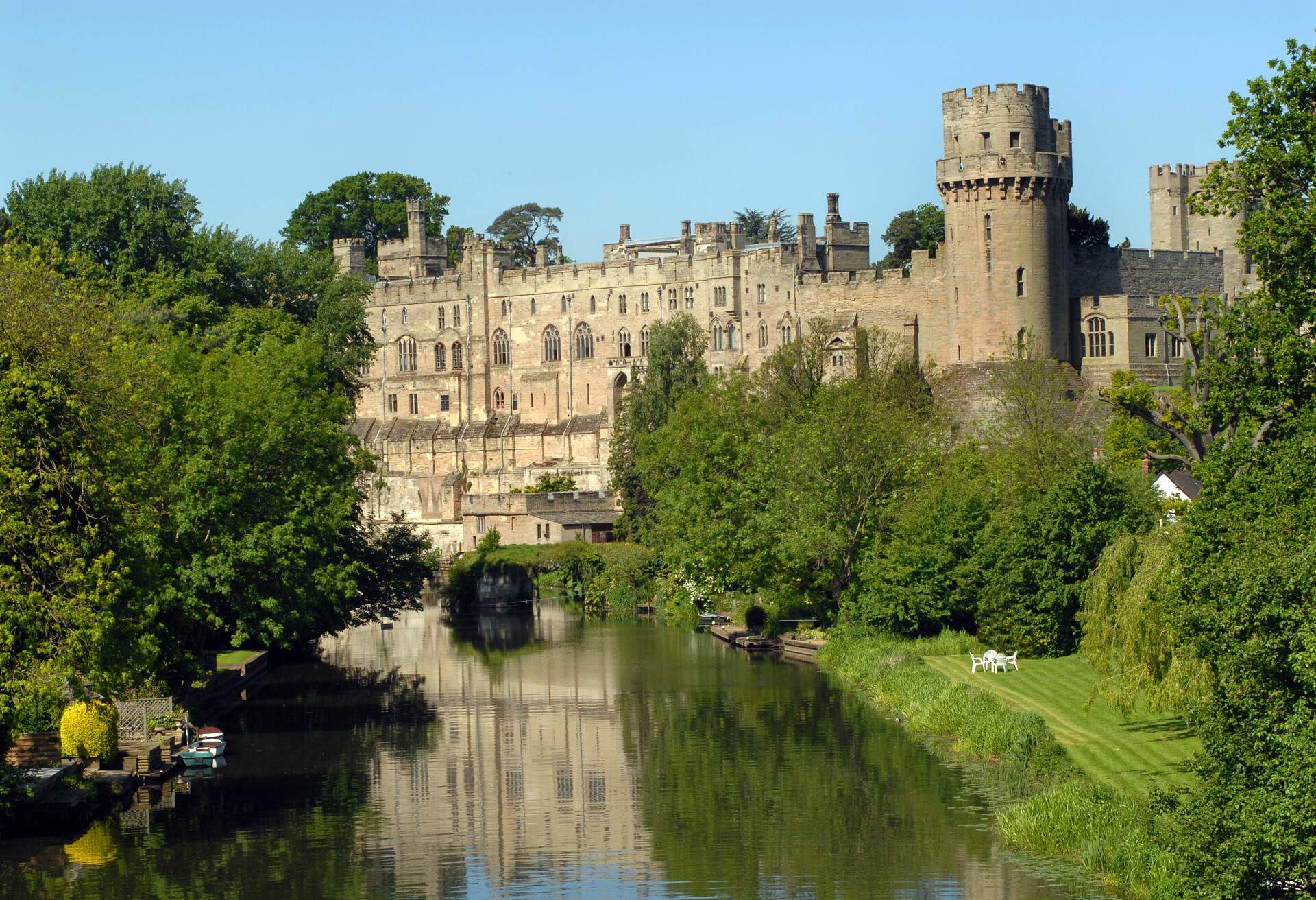 Warwick Castle reflected in the river on a beautiful spring morning.