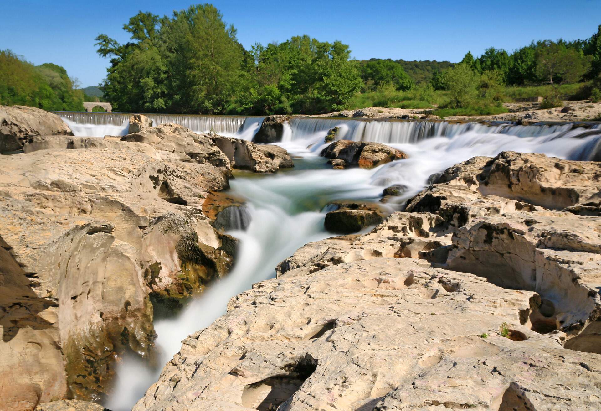 Water gushing through limestone rocks into a waterfall.