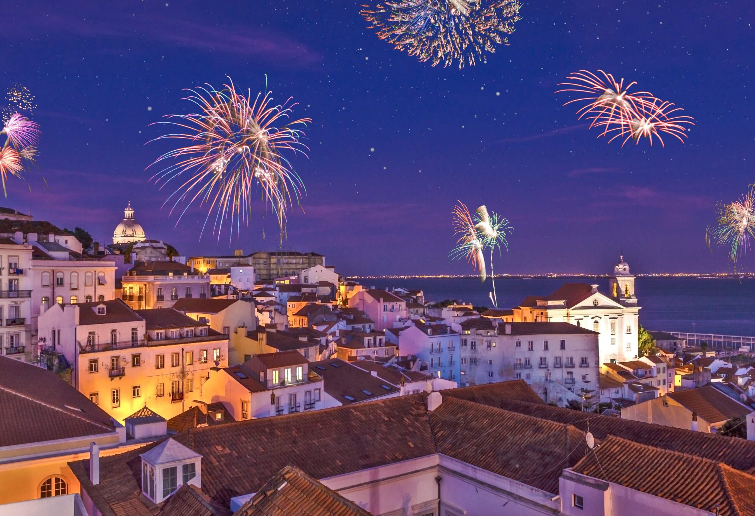 Fireworks illuminating the night sky above a historic town.