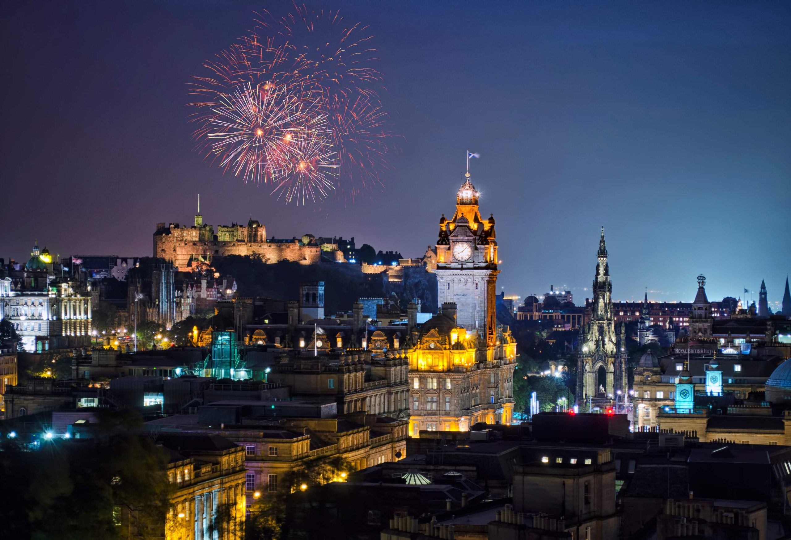 Fireworks bursting in the night sky above the city skyline.