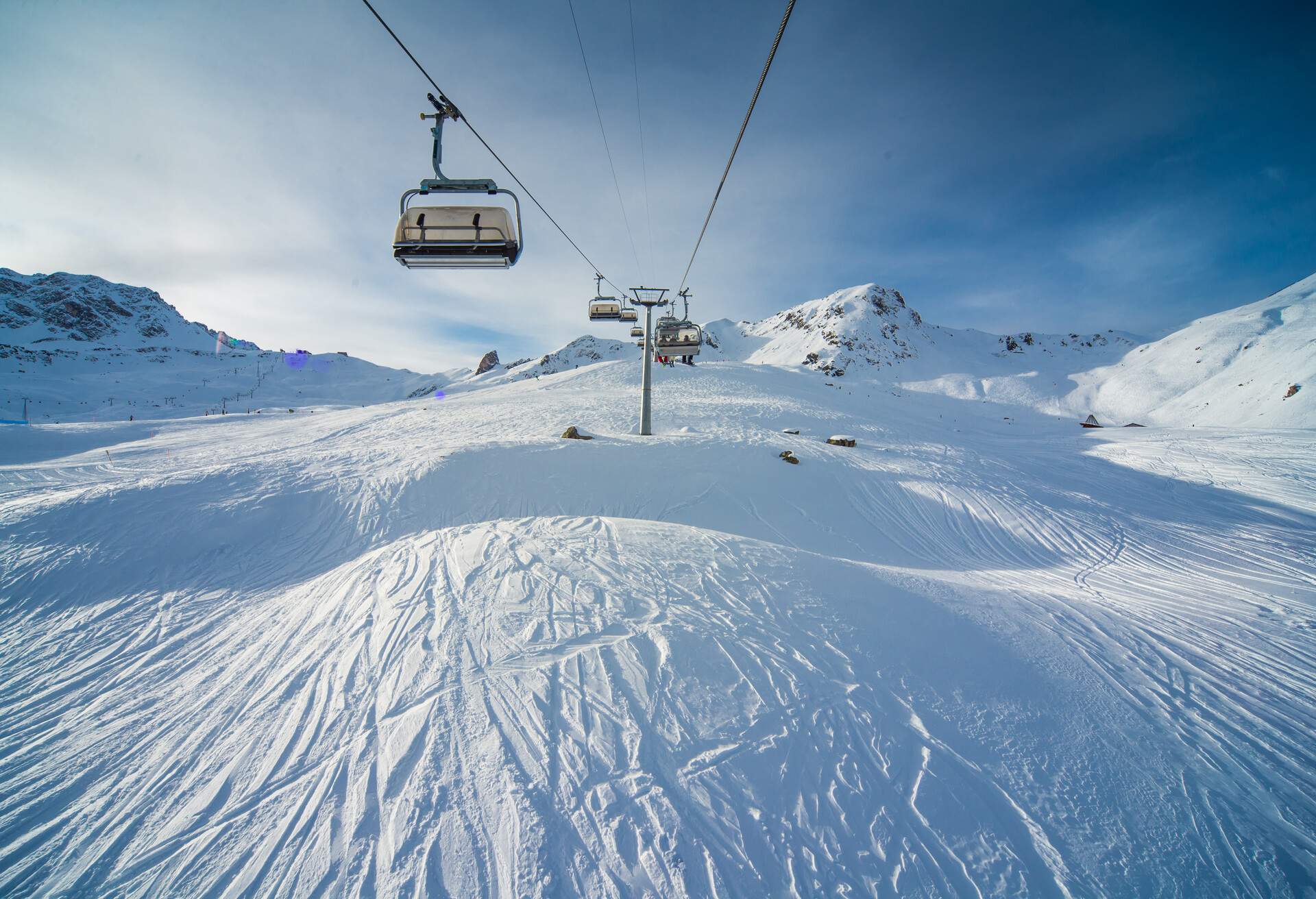 Chairlift in a ski ressort in the Swiss alps on a sunny but cold winter day. Snow covered mountains.