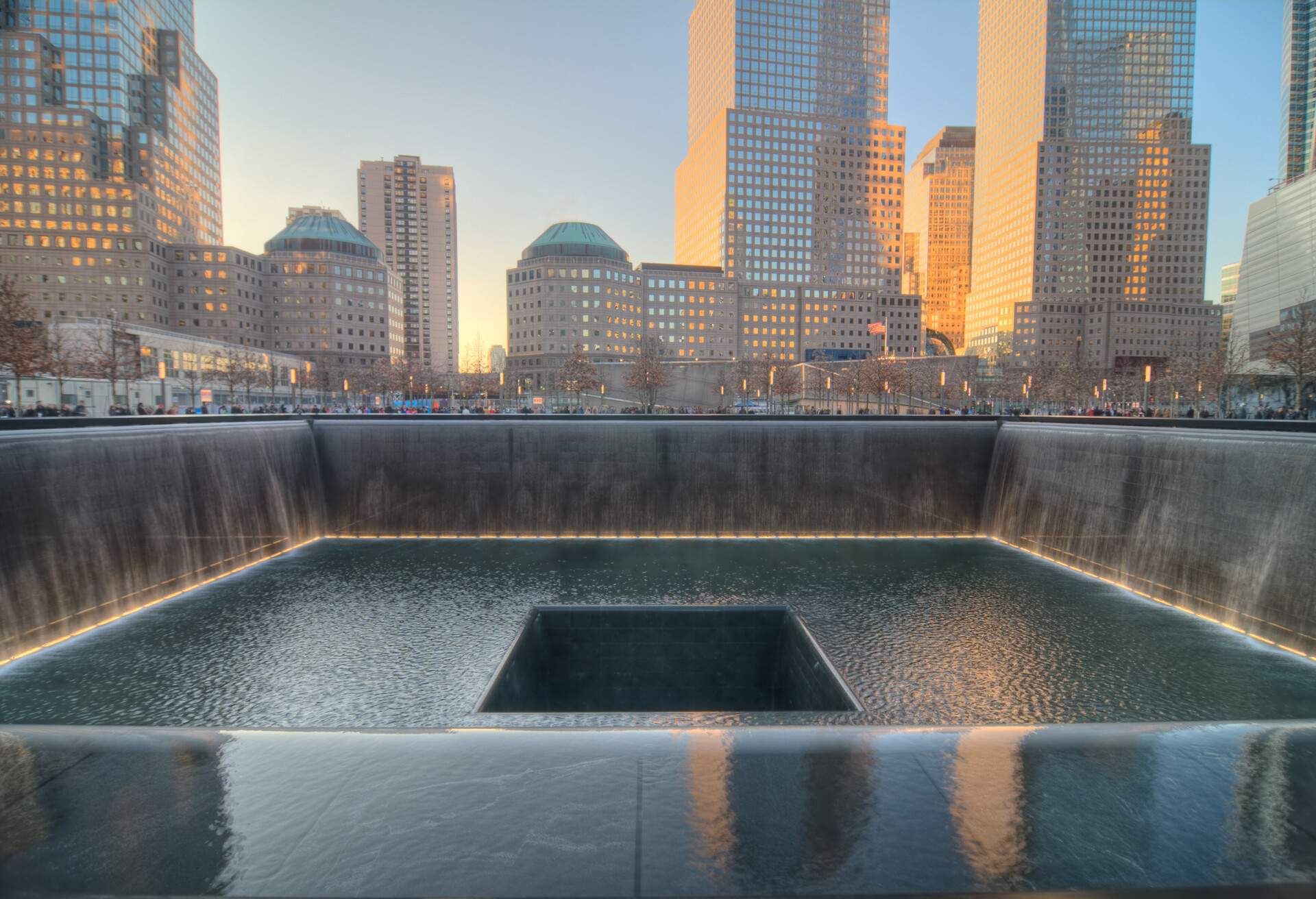 The solemn 9/11 Memorial at the World Trade Centre's Ground Zero in NYC encompasses the vast void, symbolising the immense loss and devastation.