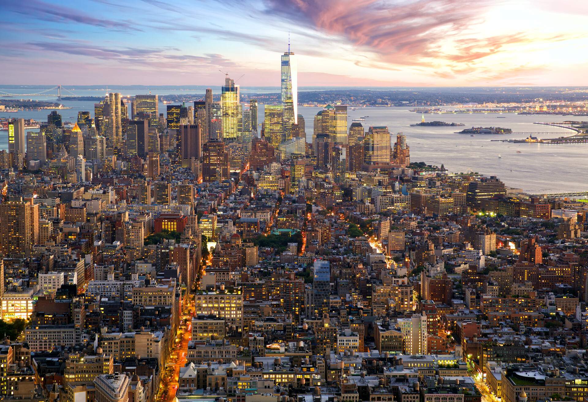 Two parallel bustling, brightly lit streets run through the cityscape towards the harbour.