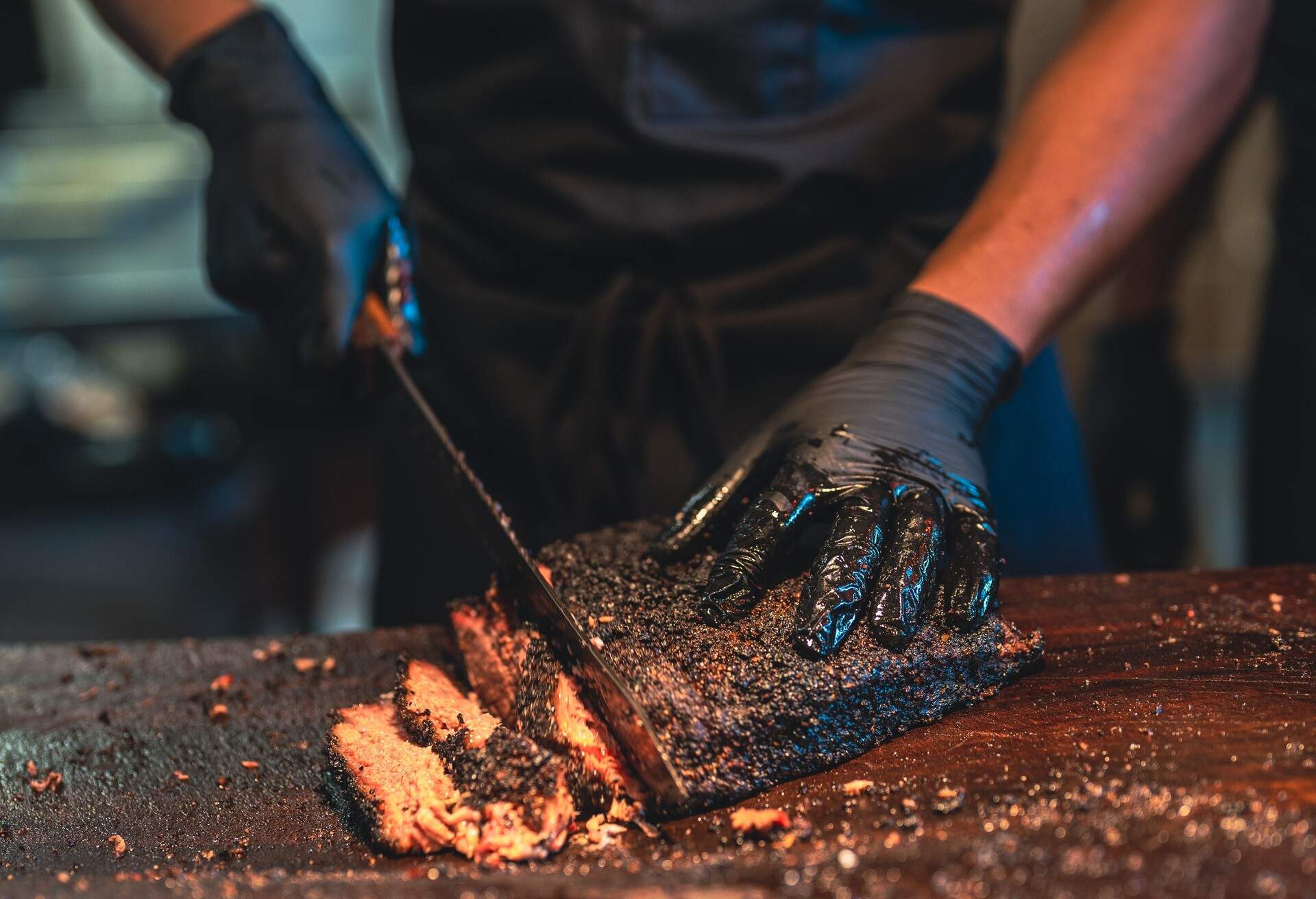 A BBQ chef prepares a delicious serving of smoked Brisket.