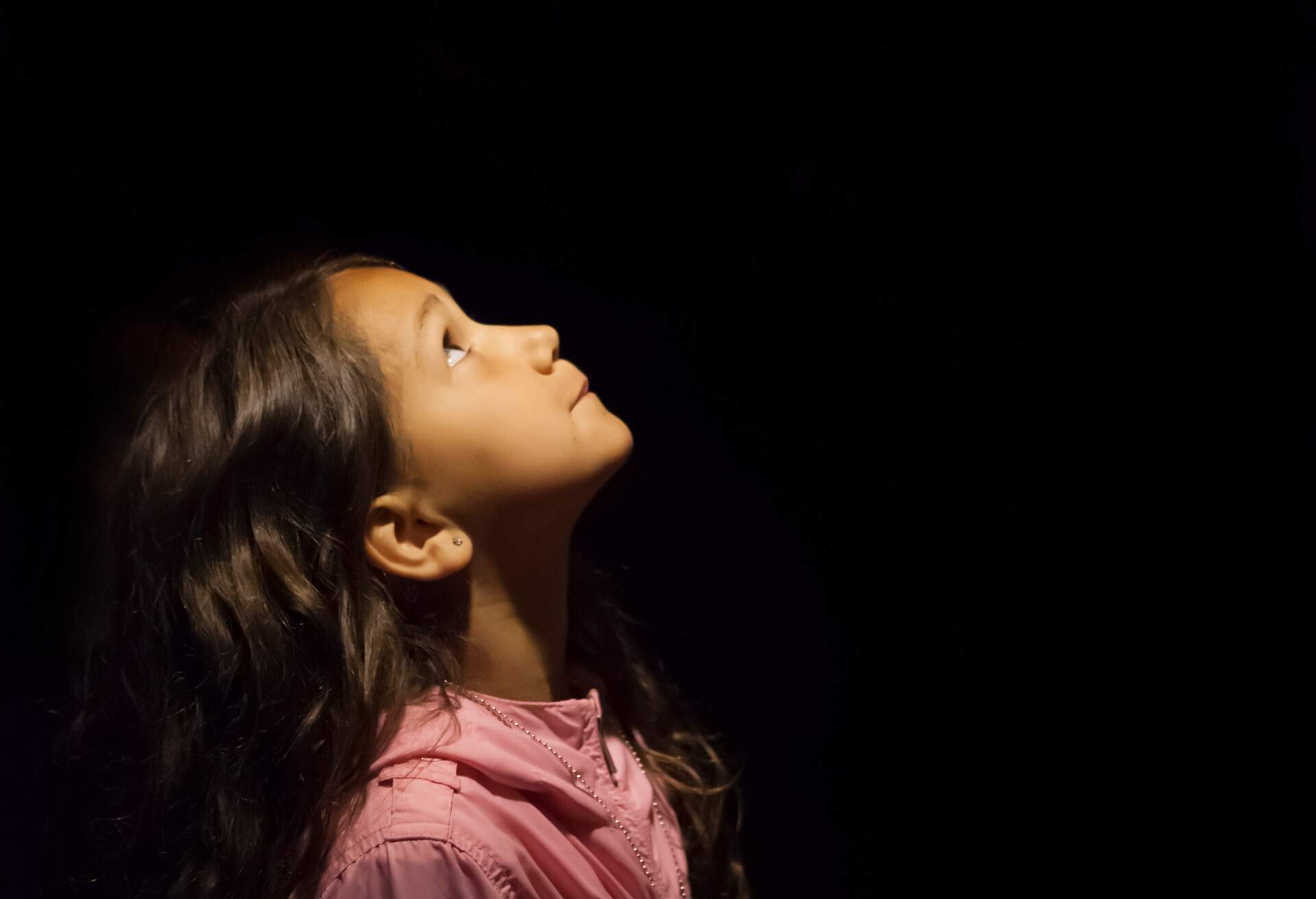 Curious little girl exploring rock formations in a cave