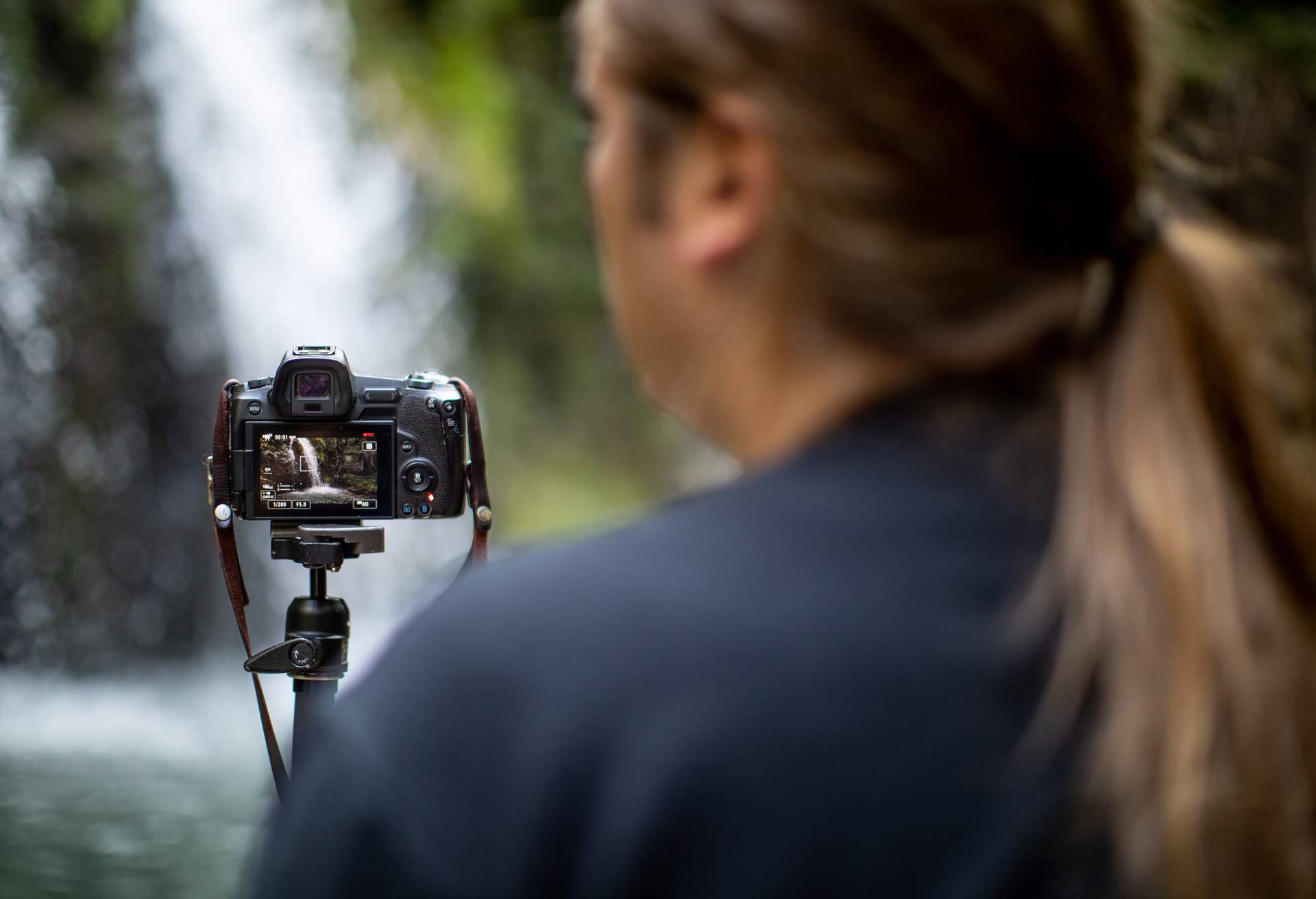 Nature Photographer Photographing Flowing Water of a Waterfall.