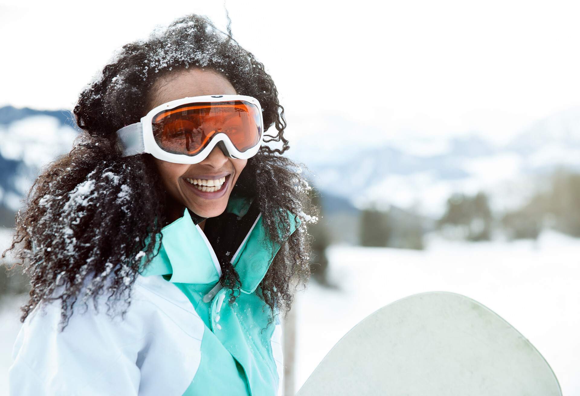 portrait of young woman in the snow with snowboard, on winter holiday