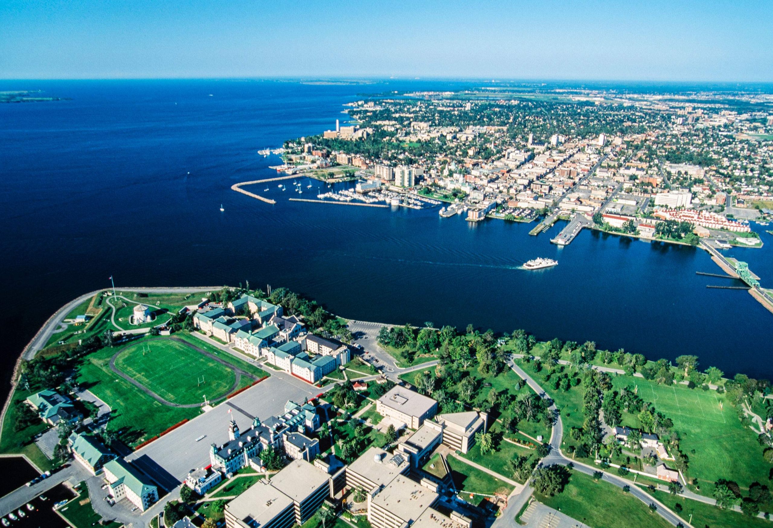 A cluster of buildings, a fort, and a forested park along the junction of two rivers.